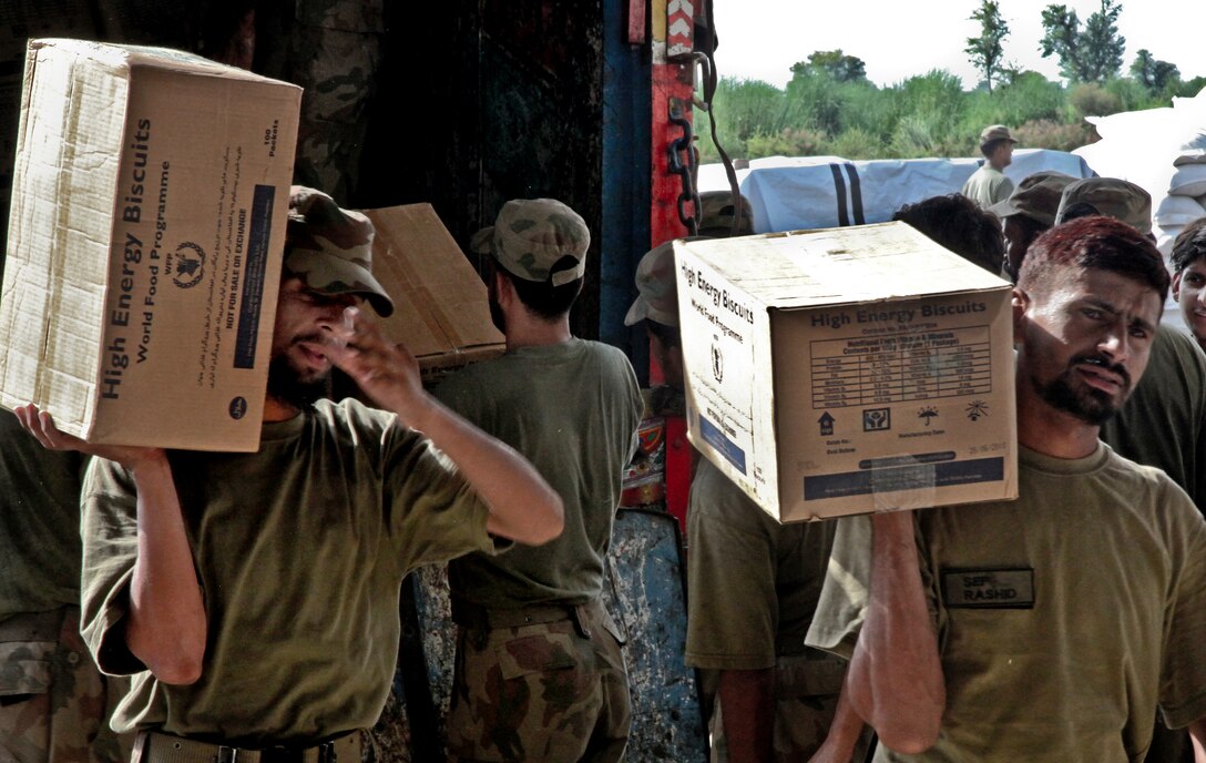 Pakistani soldiers unload boxes of food and supplies to be delivered to survivors in support of the Pakistan flood relief effort in Pano Aqil, Pakistan, Sept. 13, 2010.