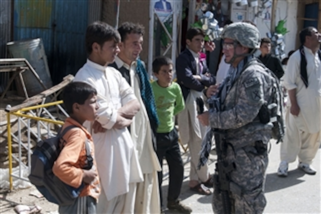 U.S. Air Force Lt. Col. Curtis Velasquez (2nd from right), commander of the Kapisa Provincial Reconstruction Team, speaks with residents of Shawani village in the Kapisa province of Afghanistan during a mission to inspect the progress of a newly constructed school in the village of Malikar in Kapisa.  Provincial Reconstruction Teams work to stabilize Afghanistan by mentoring and constructing basic infrastructure, enabling local governments to care for, educate, employ and protect their people.  