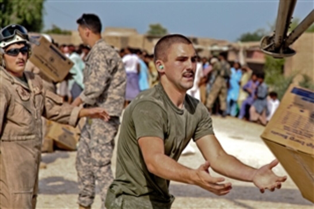 U.S. servicemembers work together to unload food and supplies from a U.S. Marine CH-53E Sea Stallion helicopter in support of the Pakistan flood relief effort in Pano Aqil, Pakistan, Sept. 14, 2010.