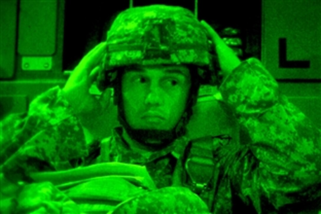 As seen through a night-vision device, a U.S. Army soldier gears up before an airborne insertion during a joint forcible entry exercise on Pope Air Force Base, N.C., Sept. 14, 2010. The event occurs six times a year to enhance cohesiveness between the Air Force and the Army. The soldier is assigned to the 82nd Airborne Division.