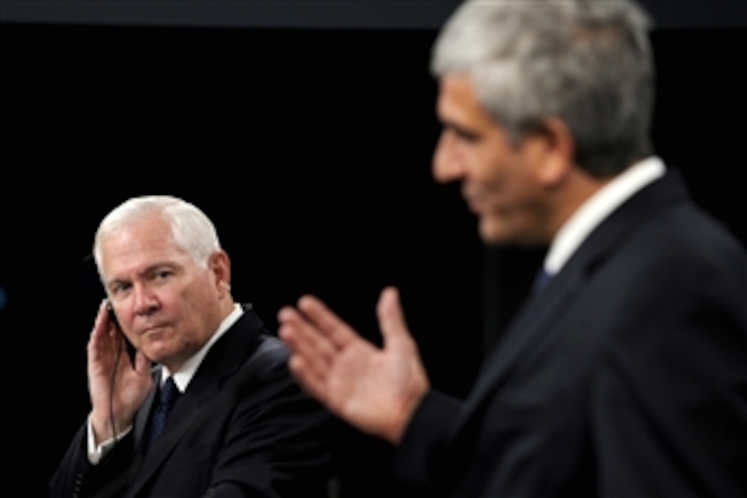 Defense Secretary Robert M. Gates, left, listens to the translation as French Minister of Defense Herve Morin responds to a reporter's question in his native language, during a joint press conference in the Pentagon, Sept. 16, 2010.