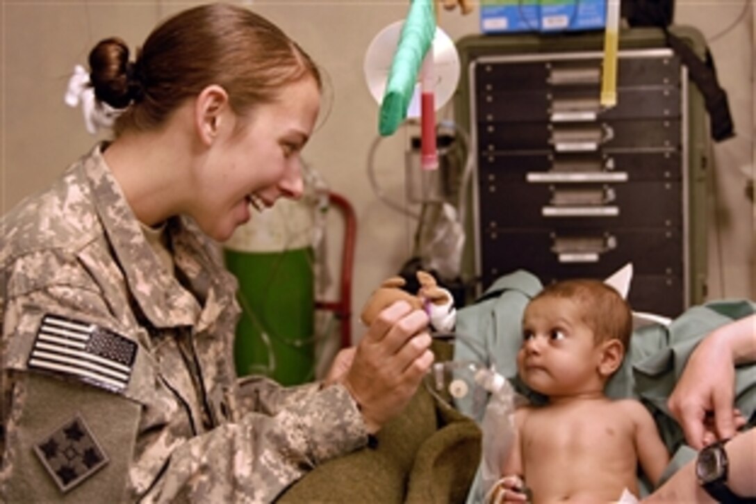 U.S. Army Spc. Samantha Romero shows Rafi his new Chemlite mobile, handmade by medics at the medical aid station on Camp Nathan Smith, Afghanistan, Sept. 15, 2010. Romero, 
a medic is assigned to the 4th Infantry Division's Headquarters Company, 1st Brigade Combat Team. 'Rafi', a 6-month-old Afghan boy, was admitted to the clinic Sept. 14 for complications related to a rare congenital heart defect.