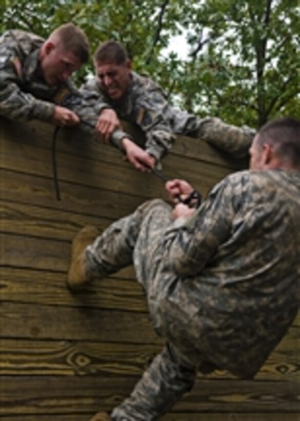 U.S. soldiers competing in the Army Warfighter Challenge attempt to pull their comrade over a fifteen foot wall at the obstacle course on day two of the challenge at Fort Leonard Wood, Mo., on Sept. 14, 2010.  The 14th Annual Warfighter Challenge brings Military Police units throughout the Army together to determine who is the best in the field of Military Police.  