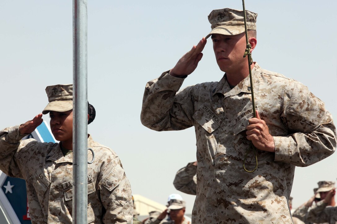 Corporal Erica Lila and Sgt. Joel Chuprevich, with Headquarters Battalion, 1st Marine Division (Forward), render honors to the flag during a Colors and Memorial Dedication ceremony held aboard Camp Leatherneck, Afghanistan, Sept. 16, 2010. The memorial ceremony was held in honor of the fallen heroes of 1st Marine Division lost while in support of the Operation Enduring Freedom.  Lila is a native of Houston, Texas, and Chuprevich is from Charlotte, N.C.