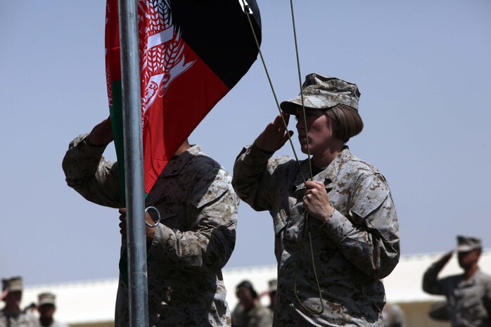 Sgt. Theresa Pavelek, with Headquarters Battalion, 1st Marine Division (Forward), renders honors to the Afghan flag during a Colors and Memorial Dedication ceremony held aboard Camp Leatherneck, Afghanistan, Sept. 16, 2010. The memorial ceremony was held in honor of the fallen heroes of 1st Marine Division lost while in support of the Operation Enduring Freedom. Pavelek is a native of Baraboo, Wisc.