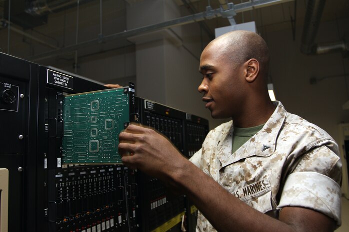 Lance Cpl. Brandon L. Fernandez, a Headquarters and Headquarters Squadron Ground Electronics Maintenance Division communications technician, troubleshoots an enhance terminal voice switch card, which keys radios that air traffic controllers use to communicate with pilots. GEMD is responsible for all facets of maintenance, repair and control of airfield navigational aids, communications and other support equipment.