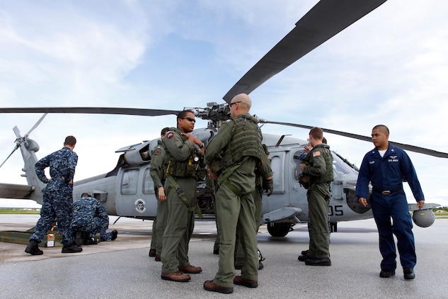 Helicopter Sea Combat Squadron 25 pilots stand by at the flight line here as HSC-25 ordnance sailors load ammunition aboard the MH-60 Knighthawk for a live-fire sink exercise as part of exercise Valiant Shield 2010, Monday.