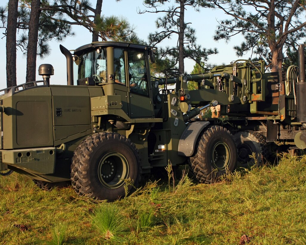 A TRAM, the Marine Corps' acronym for tractor, rubber-tired, articulated steering, multi-purpose, unloads an 805A generator off a 7-ton truck for a 22nd Marine Expeditionary Unit communication exercise at Operations Point 2 aboard Camp Lejeune, N.C., Sept. 16, 2010. The exercise was designed to give the Marines hands on training in a field environment for a future deployment in which the equipment may be used.
