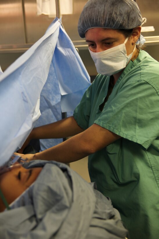 Lance Cpl. Nubia Z. Leon-Lozano, native of Carson City, Nev., and field operator with Marine Air Control Squadron 2, Command Element of Special-Purpose Marine Air-Ground Task Force Continuing Promise 2010, checks a 13-year-old Nicaraguan child during her umbilical hernia repair operation aboard the USS Iwo Jima, Sept. 17, 2010. Leon-Lozano served as a Spanish translator for shipboard surgeries. Marines and Sailors of CP10 worked together to support surgical operations off the coast of Bluefields, Nicaragua. CP10 is a humanitarian civic assistance mission, where USS Iwo Jima personnel is providing medical, dental, veterinary, engineering support and disaster relief efforts to the Caribbean, Central and South America.