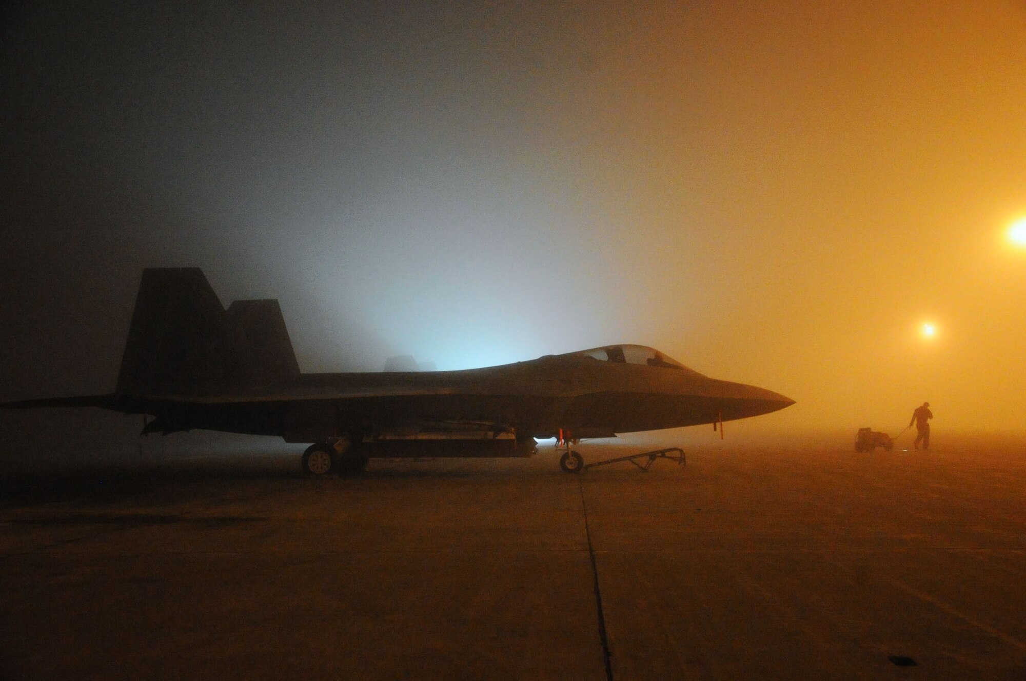 JOINT BASE ELMENDORF-RICHARDSON, Alaska -- A crew chief with the 90th Aircraft Maintenance Unit pulls a hydraulic cart while servicing F-22 Raptors on the flightline. (Air Force photo by Senior Airman Cynthia Spalding)