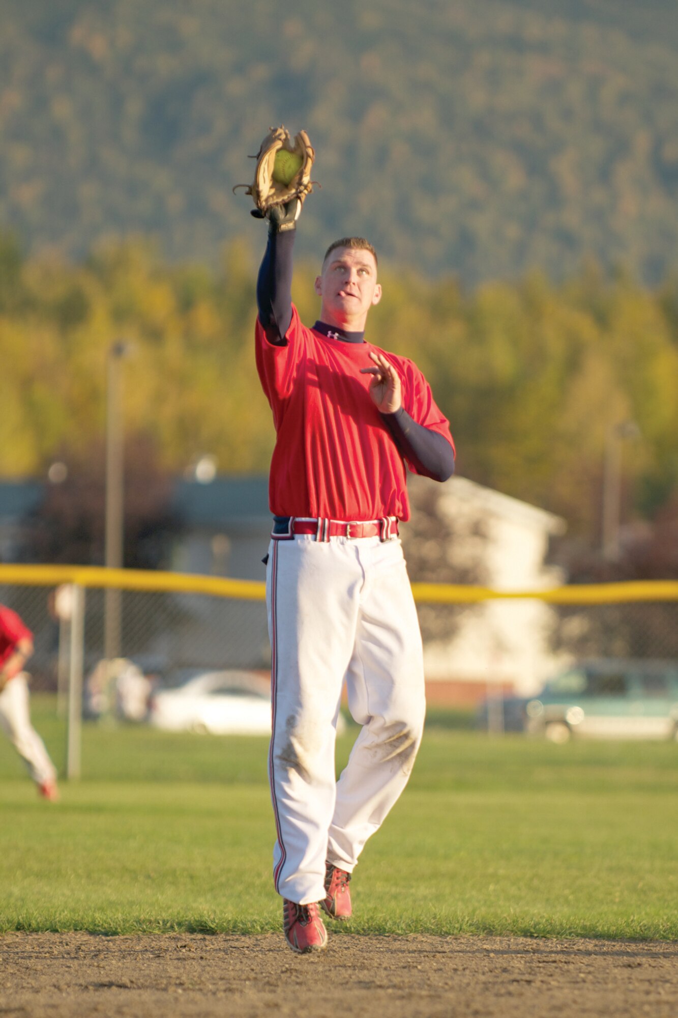 Jeffrey Tongate, JBER 673d ABW Fire and Emergency Department shortstop, leaps for an easy out in game 1. The teams’ indentically colored red jerseys made officiating difficult for the two Amateur Softball Association of America umpires. (Photo by David Bedard/JBER PAO)