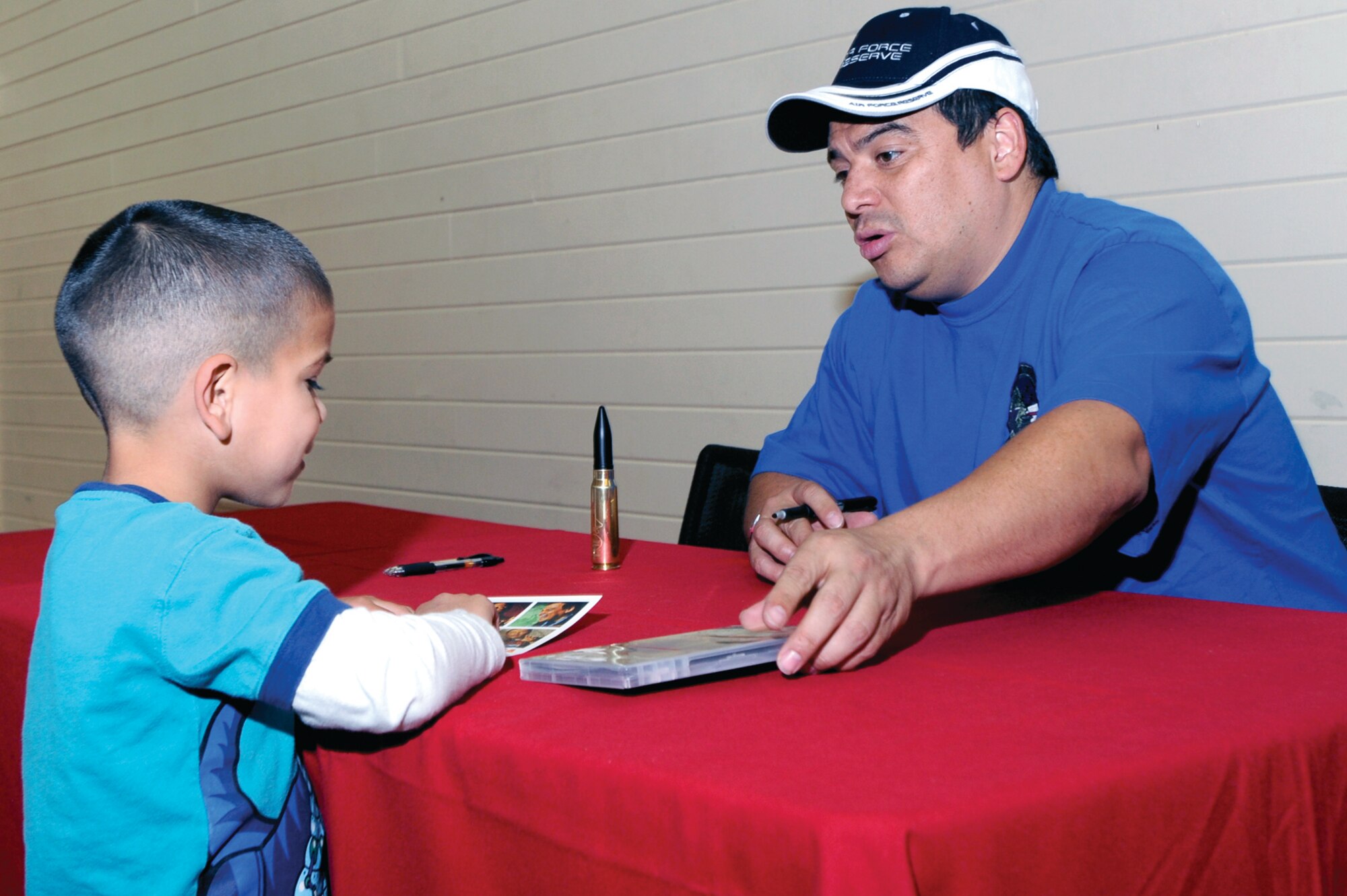 Carlos Mencia talks with Michael Hernandez, son of Pfc. Michael Hernandez, 17th Combat Sustainment Support Battalion, during the meet and greet at the Elmendorf
Fitness Center, here, Sept. 10. (Photo by Air Force Staff Sgt. Joshua Garcia/JBER PAO)