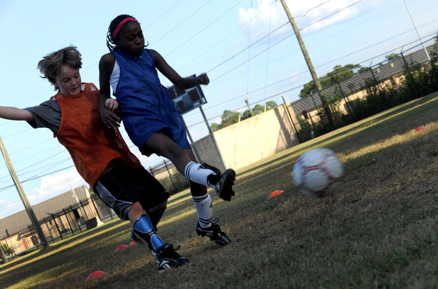 MOODY AIR FORCE BASE, Ga. -- Kelsey Smith, daughter of Staff Sgt. Paul Newbauer, 23rd Civil Engineer Squadron, kicks a soccer ball by Bryce Holthus, son of Katrina Holthus, 822nd Security Forces Squadron, during youth soccer practice here Sept. 16. During practice, the youth members were separated into offense and defense groups and played against each other. (U.S. Air Force photo/Airman 1st Class Benjamin Wiseman)