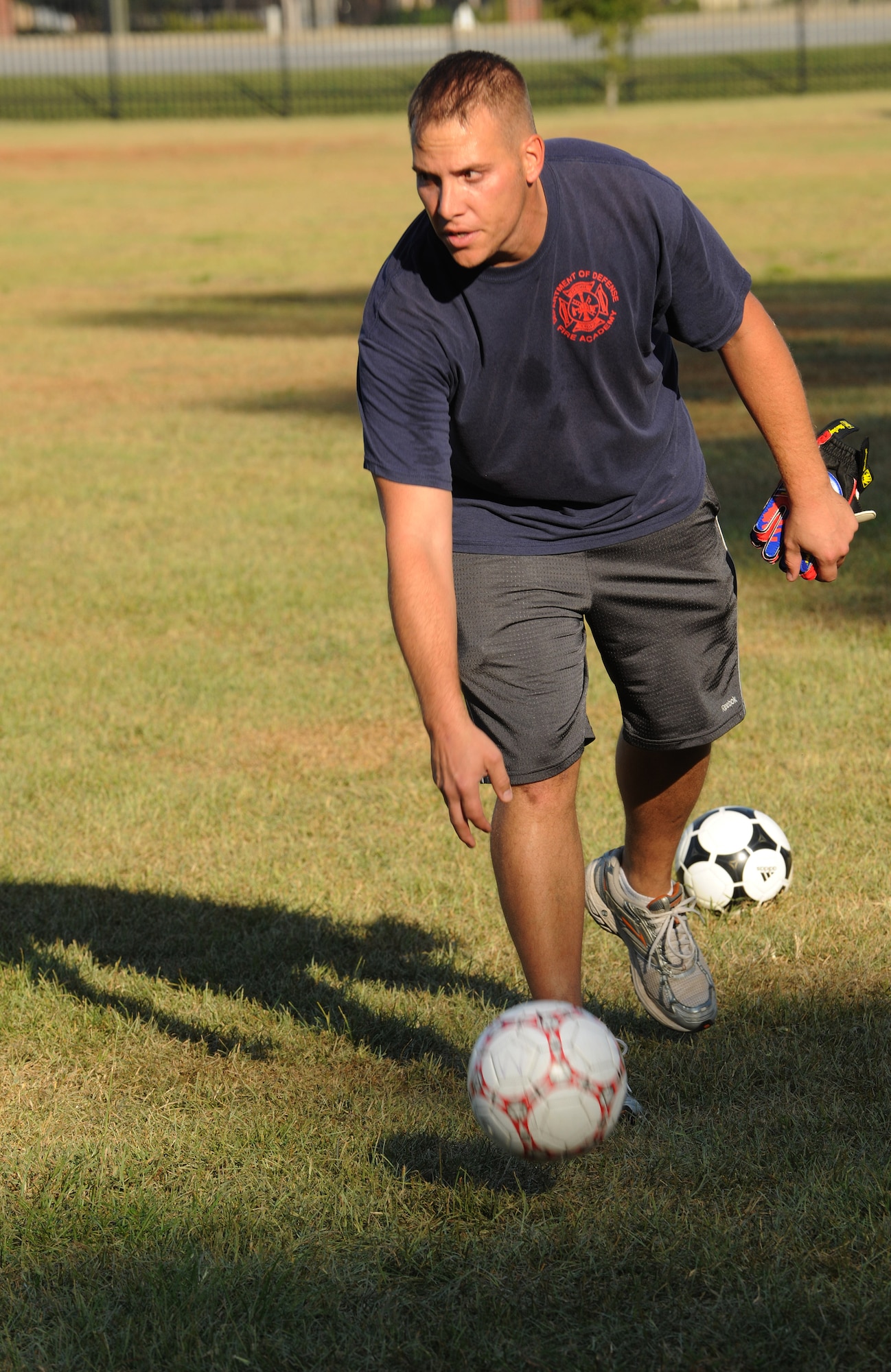 MOODY AIR FORCE BASE, Ga. -- Staff Sgt. Robert Sturman, 23rd Civil Engineer Squadron vertical shop, kicks a soccer ball during youth soccer practice here Sept. 16. Sergeant Sturman coaches children between the ages of 8 and 9 years old. (U.S. Air Force photo/Airman 1st Class Benjamin Wiseman)