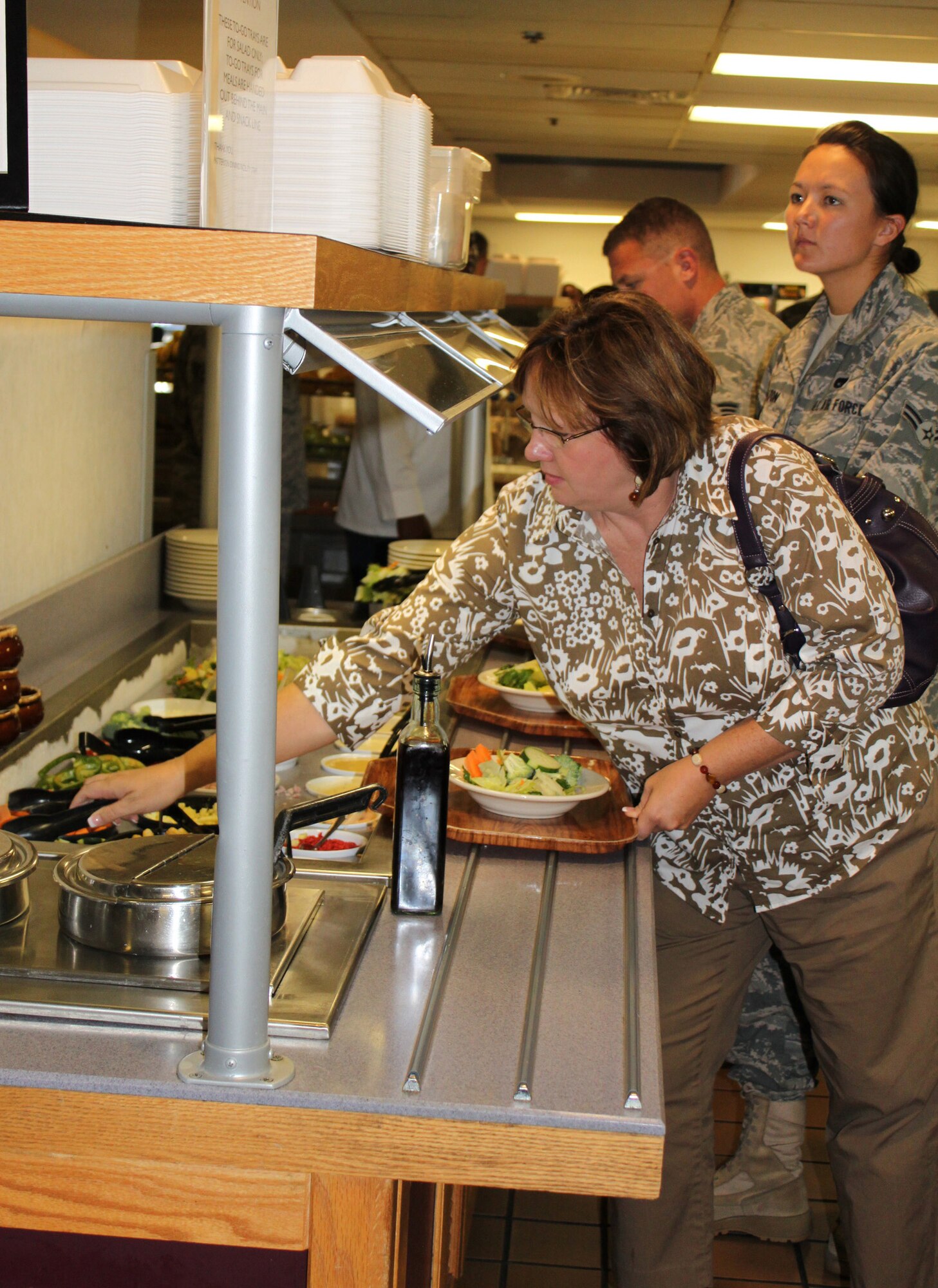 Janet Badgett, wife of Chief Master Sgt. Dwight D. Badgett, command chief of Air Force Reserve Command, makes a salad at the Patterson Dining Facility Sept. 11, 2010. Mrs. Badgett accompanied her husband for a visit to Dover Air Force Base, Del., during the September Unit Training Assembly and hosted an Airmen?s lunch with Liberty Wing Airmen at the dining facility. (U.S. Air Force photo by Tech. Sgt. Christin Michaud/Released)