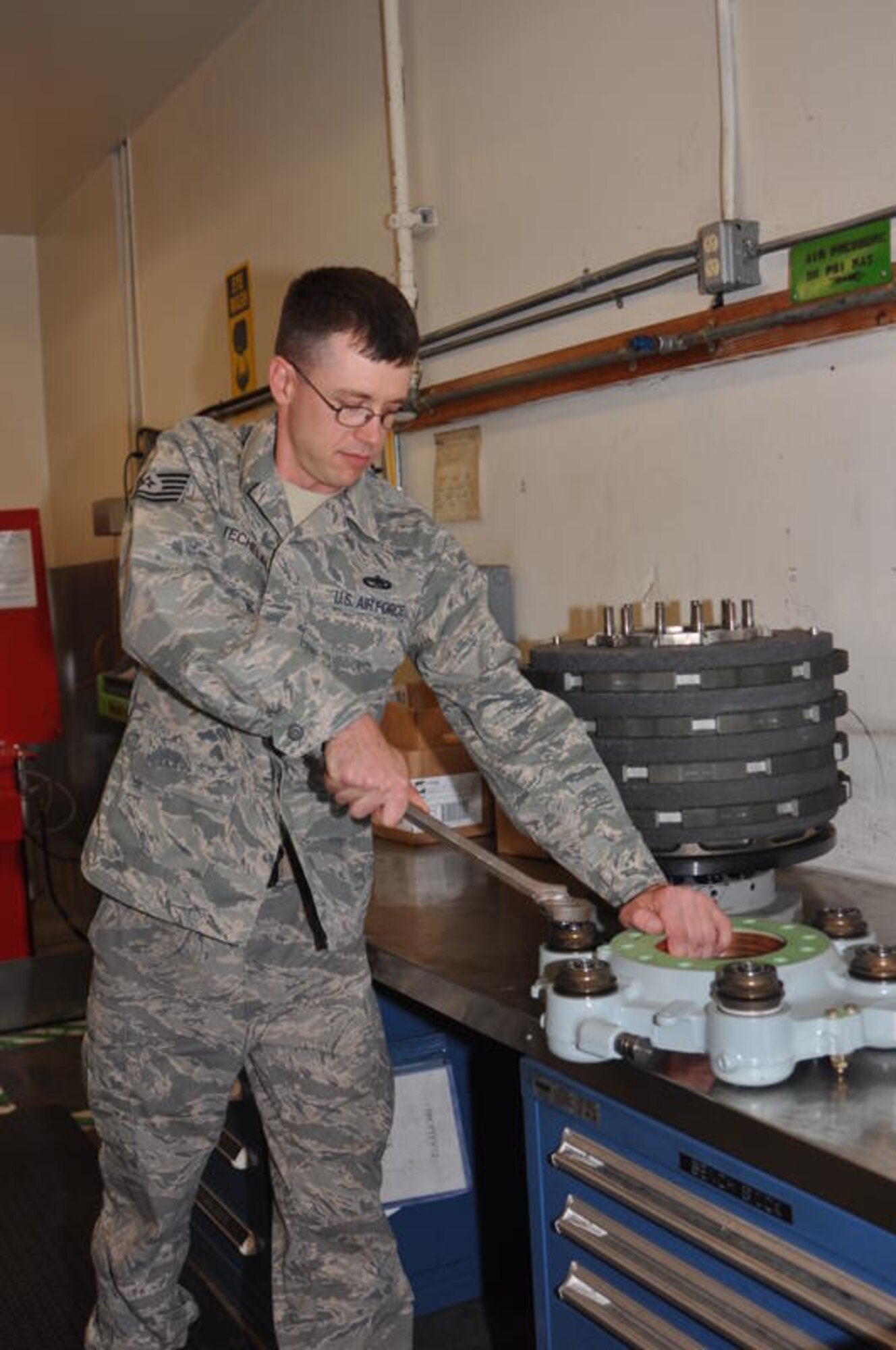 Tech. Sgt. Matthew Stechelin, 60th Maintenance Squadron hydraulic systems shop supervisor, uses the tool he invented to remove an insulator cap from the brake of a C-17.
