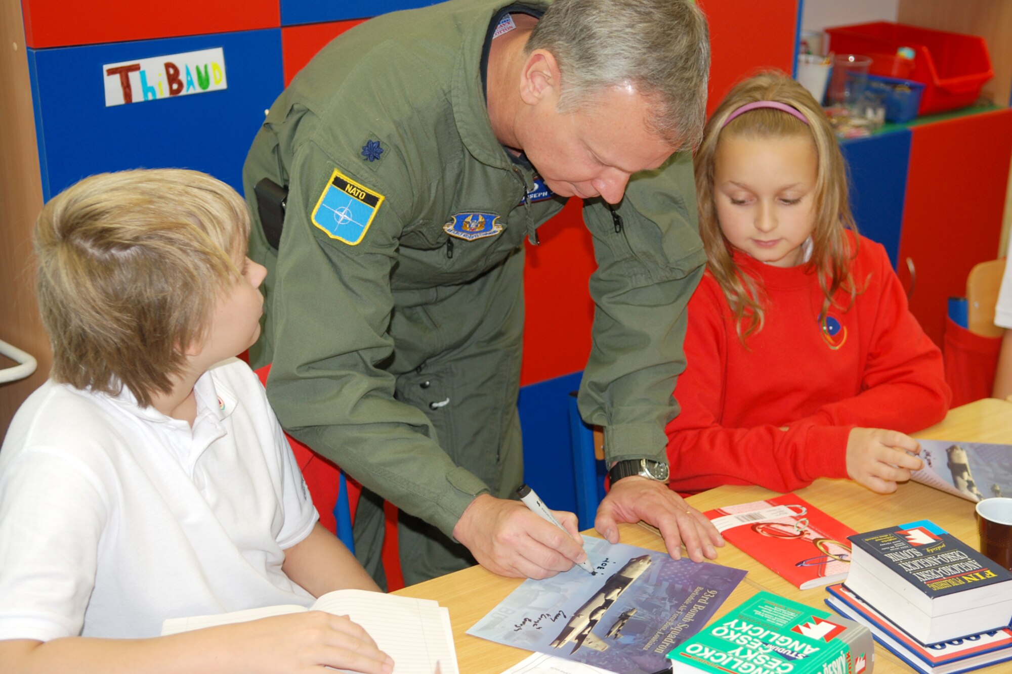 Lt. Col. Joseph Jones, 93rd Bomb Squadron commander, signs a 93rd BS fact sheet handout for kids attending the 1st International School of Ostrava, Ostrava, Czech Republic, on Sept 17, 2010. The 93rd BS is assigned to the 917th Wing, Barksdale Air Force Base, La., which supplied a B-52H Stratofortress in support of the 10th NATO Days in Ostrava & 1st Czech Air Force Days Air Show being held Sept 18-19, 2010, at the Leos Janacek Ostrava Airport, Ostrava, Czech Republic. (U.S. Air Force photo/Master Sgt. Greg Steele)