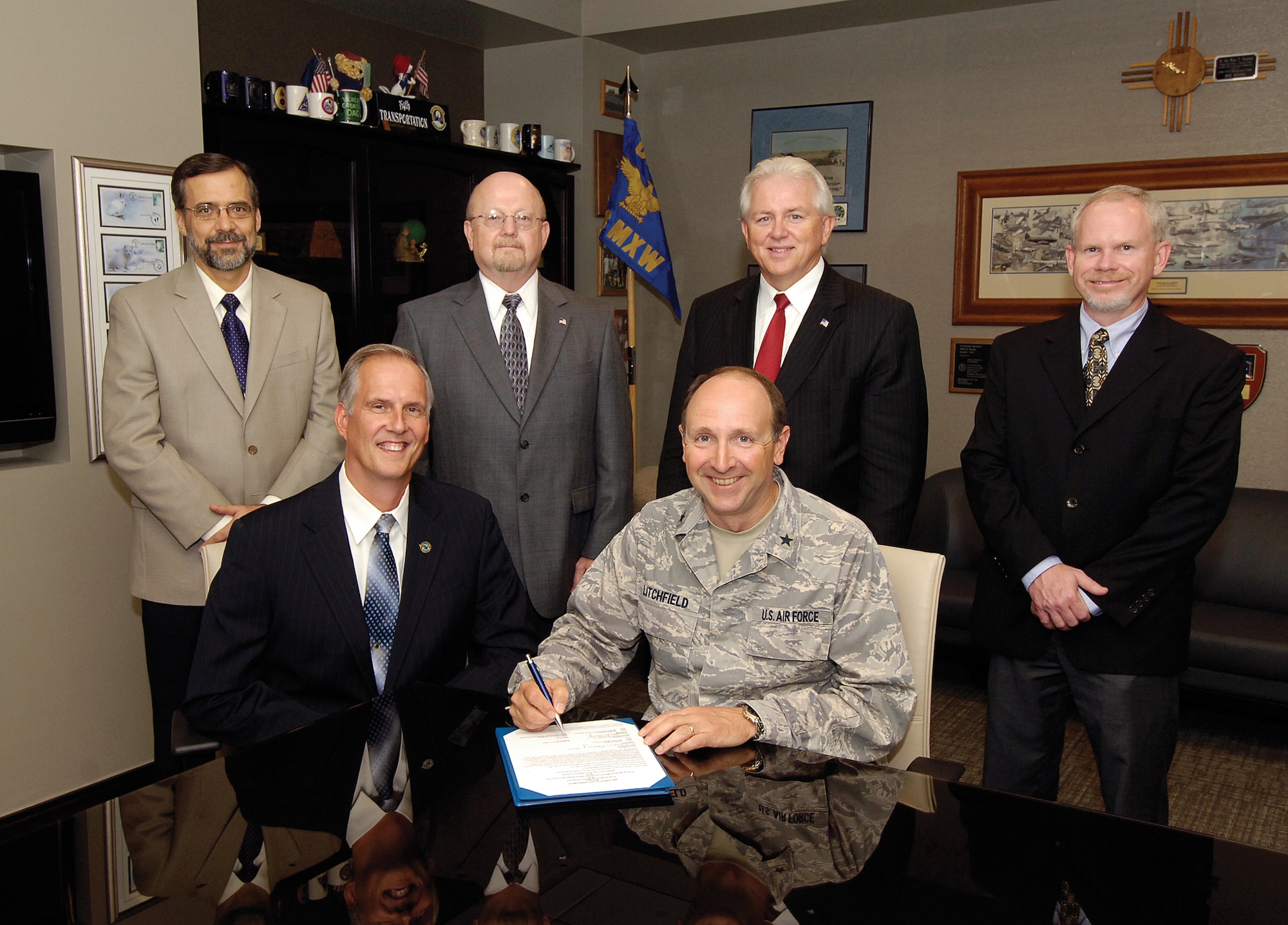 With the stroke of a pen, Tinker and Pratt & Whitney officials agreed Sept. 14 to the partnership that will see the F117 engine worked on here. Brig. Gen. Bruce Litchfield, 76th Maintenance Wing commander, signed the agreement as Pratt & Whitney’s Bob Johnson, seated, watched.  Also attending the signing were, back from left; Robert Kusbel, 76th MXW Business Development Branch chief; Floyd Craft, 547th Propulsion Maintenance Squadron director; Dan Mooney, 76th Propulsion Maintenance Group deputy director; and Leonard Hayes, F117 program manager. “We’re ready,” said General Litchfield after signing the agreement. “It’s time to go to work.” Tinker is the third heavy maintenance center for the F117 and the first for the Air Force; the other two centers are private.  (Air Force photo by Margo Wright)