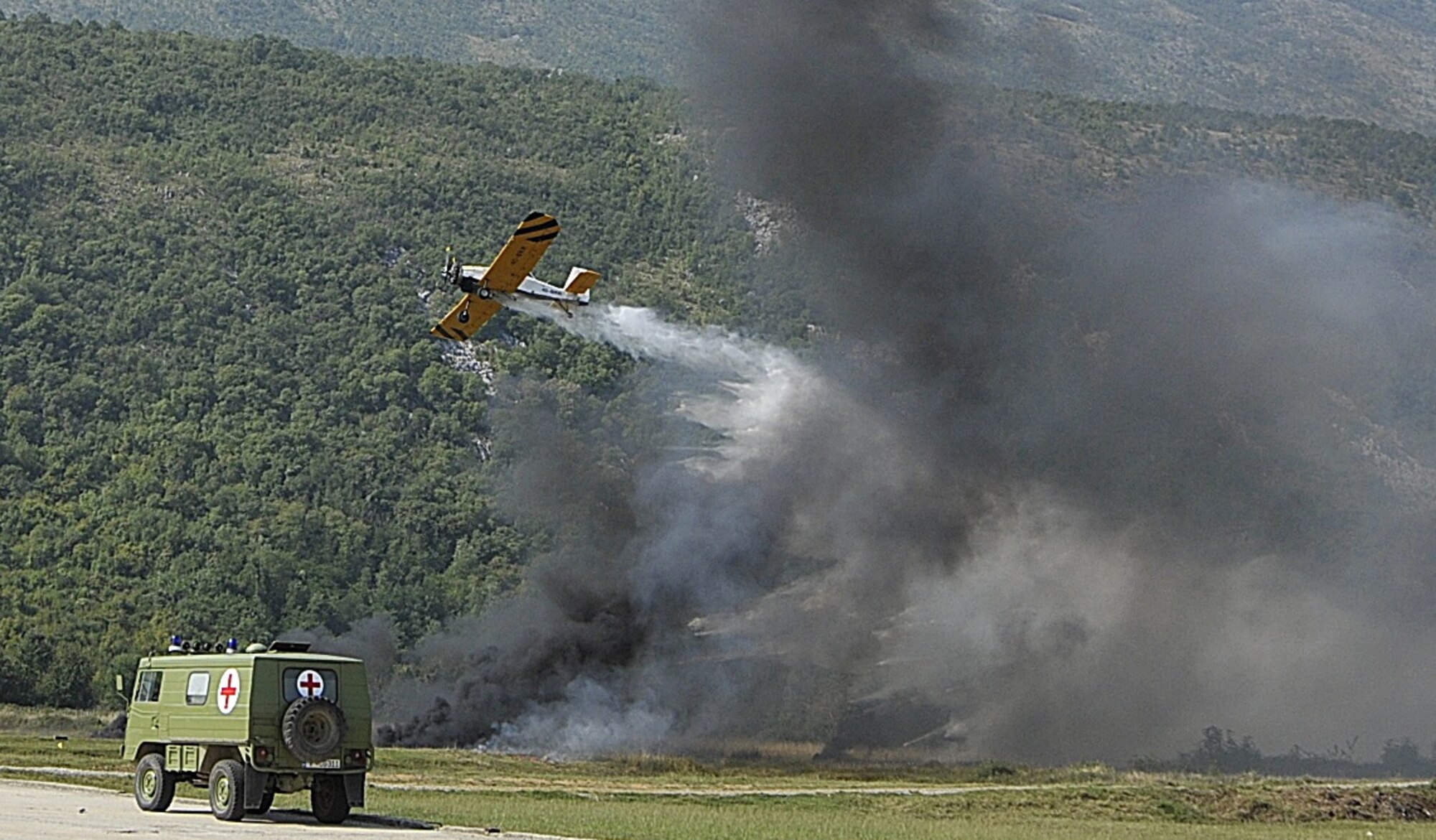 A Montenegrin airplane drops fire retardant on a mock bridge explosion fire -- a medical exercise demonstration that is part of MEDCEUR 10, a medical training exercise in central and eastern Europe, at Danilovgrad Army Base, Montenegro, Sept. 17. The scenario, along with four others, was shown to government ministers, flag officers and other honored guests during visitors day. For more information, go to www.usafe.af.mil/medceur.asp and www.odbrana.gov.me. (U.S. Air Force photo/Airman 1st Class Tiffany Deuel)