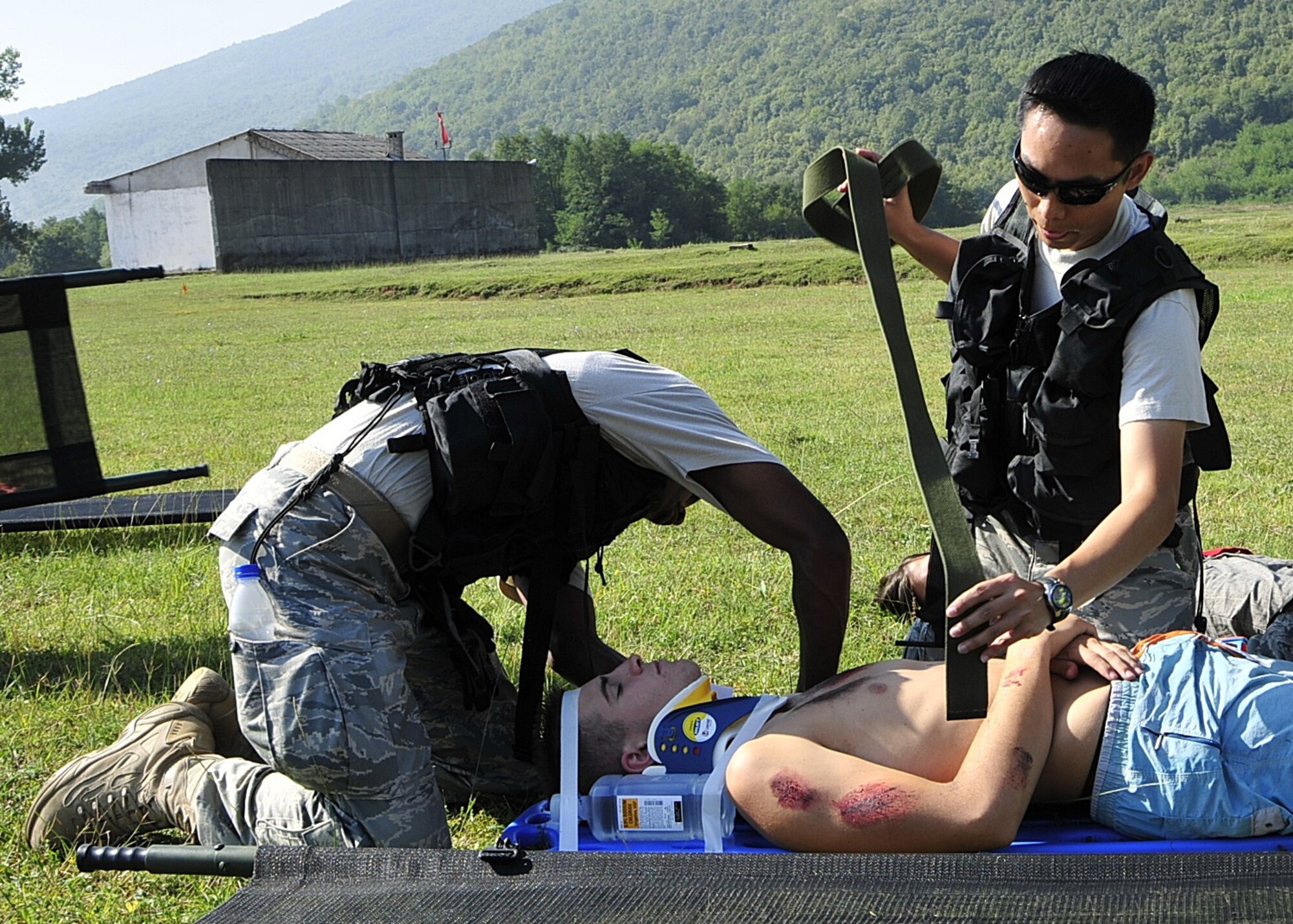 (left to right) United States Air Force Staff Sgt. James Ellison and Tech. Sgt. Jose Libunao, medical technicians of the 48th Medical Group at RAF Lakenheath, England, strap in an acting victim after a simulated bridge explosion during MEDCEUR 10, a medical training exercise in central and eastern Europe, at Danilovgrad Army Base, Montenegro, Sept. 16. Approximately 250 servicemembers from ten nations participated in various scenarios designed to provide training experience and the opportunity to learn how to work together effectively to save lives. For more information, go to www.usafe.af.mil/medceur.asp and www.odbrana.gov.me. (U.S. Air Force photo/Airman 1st Class Tiffany Deuel)