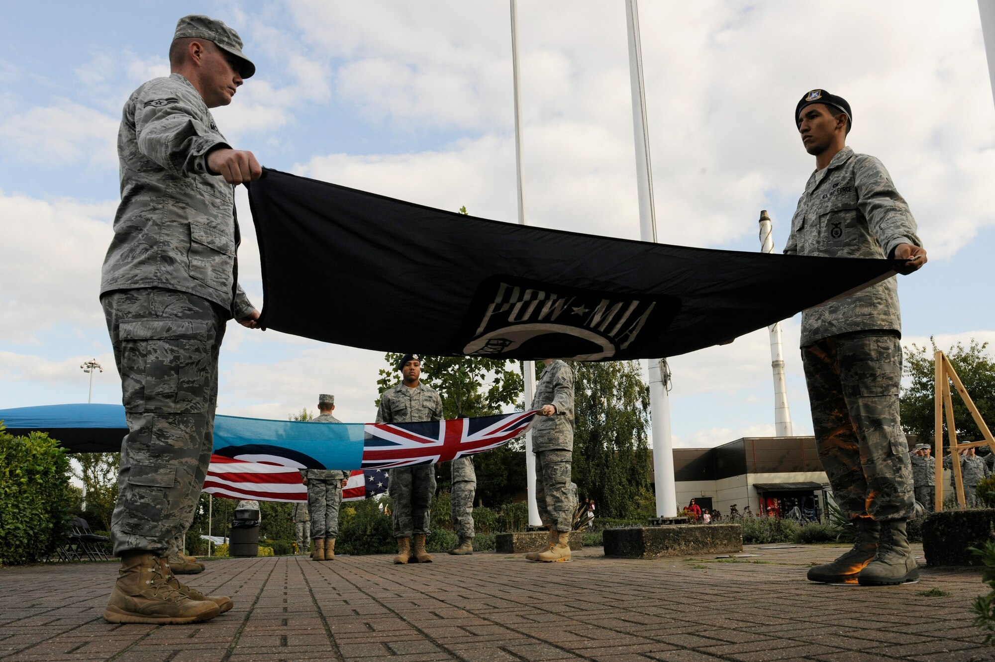 ROYAL AIR FORCE LAKENHEATH, England – Airman 1st Class Robert McNaught, 48th Civil Engineer Squadron Explosive Ordinance Disposal technician, and Airman 1st Class Robert Flatt, 48th Security Forces Squadron patrolman, prepare to fold the POW/MIA flag during a special retreat ceremony Sept. 17, 2010. (U.S. Air Force photo/Airman 1st Class Lausanne Morgan)