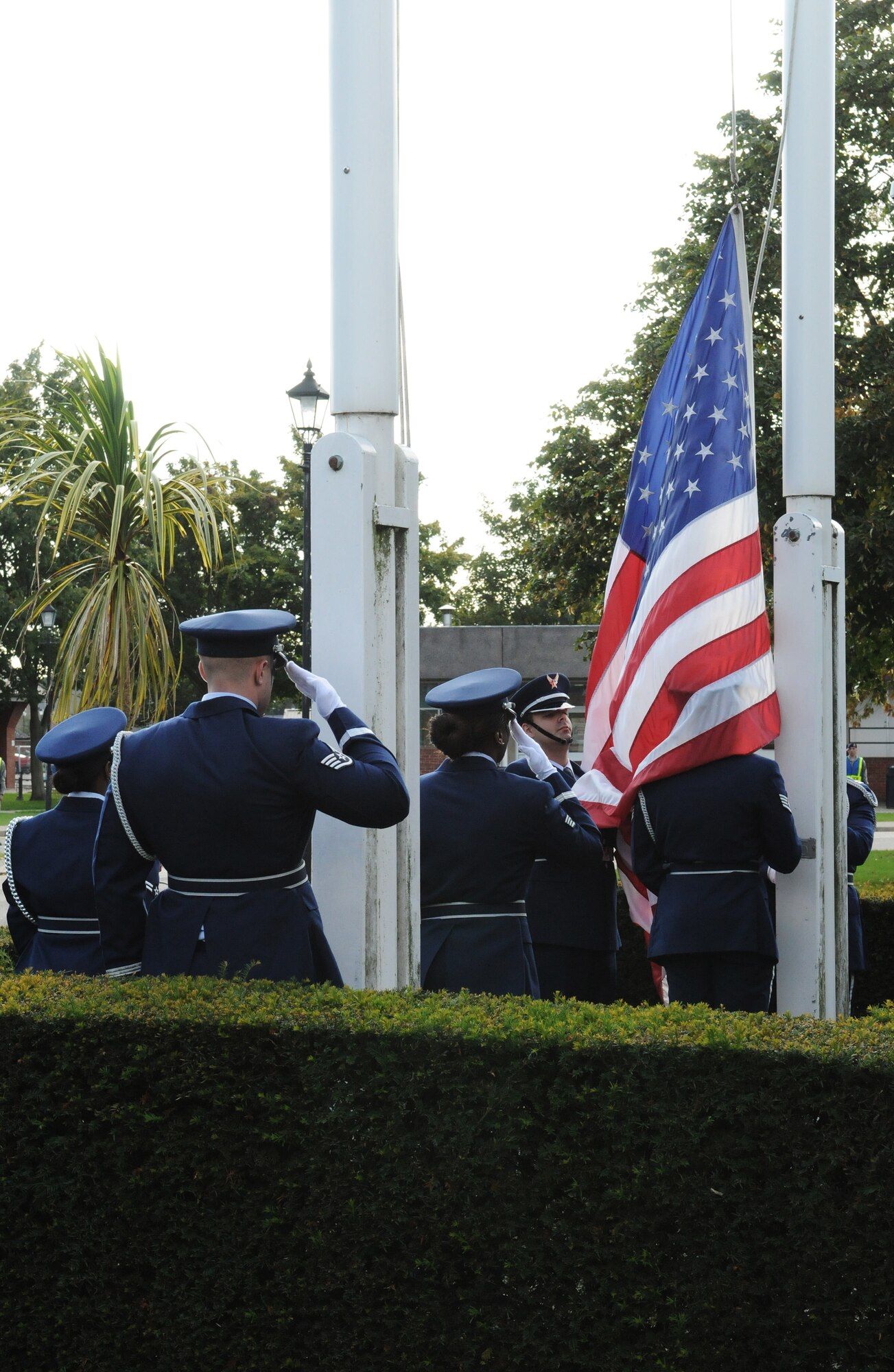RAF MILDENHALL, England -- A flag security detail lowers the colors during Retreat outside 100th Air Refueling Wing Headquarters Sept. 17. After the flag is secure, it is presented to the wing commander as a way of paying respect to the flag. This ceremony was the closing event for Prisoner of War/Missing in Action Remembrance Week. (U.S. Air Force photo/Staff Sgt. Thomas Trower) 