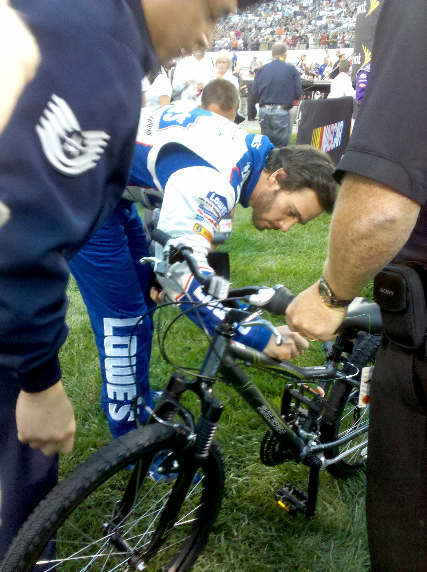 NASCAR driver Jimmy Johnson signs a bicycle for L.J., a boy who has contracted a rare form of leukemia, Sept. 11, 2010, in Richmond, Va. Through the efforts of Tech. Sgt. Michael Meinhold and Frank Russo of Dover Air Force Base, Del., L.J. will receive the bike, also signed by NASCAR driver Danny Hamlin, to replace one that was stolen from him. (Courtesy photo) 