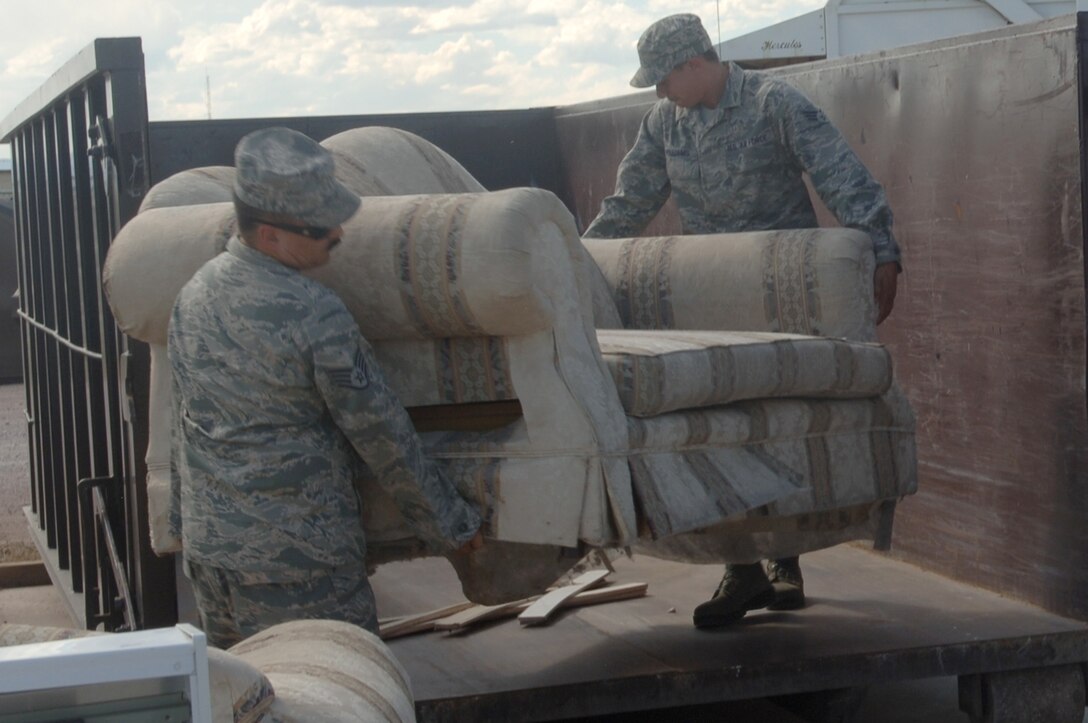 ELLSWORTH AIR FORCE BASE S.D. – Senior Airman Eugene Williams (right) and Staff Sgt. Juan Ramirez (left), 28th Maintenance Squadron aerospace ground equipment maintainers, carry an old couch into a recycling point container, Sept. 9.  The transfer station has several containers for both recyclables and regular trash.  (U.S. Air Force photo/Airman 1st Class Alessandra Hurley)