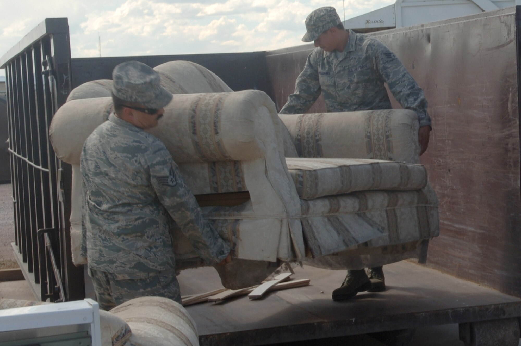 ELLSWORTH AIR FORCE BASE S.D. – Senior Airman Eugene Williams (right) and Staff Sgt. Juan Ramirez (left), 28th Maintenance Squadron aerospace ground equipment maintainers, carry an old couch into a recycling point container, Sept. 9.  The transfer station has several containers for both recyclables and regular trash.  (U.S. Air Force photo/Airman 1st Class Alessandra Hurley)