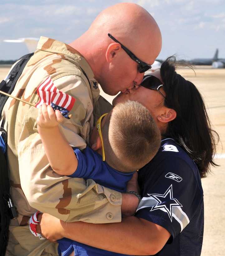 Aviation Structural Mechanic 2nd Class William Thompson, assigned to Electronic Attack Squadron VAQ-209, receives a hug and kiss from his wife and son. (Photo by MC2 (AW) (SW) Clifford L. Davis)