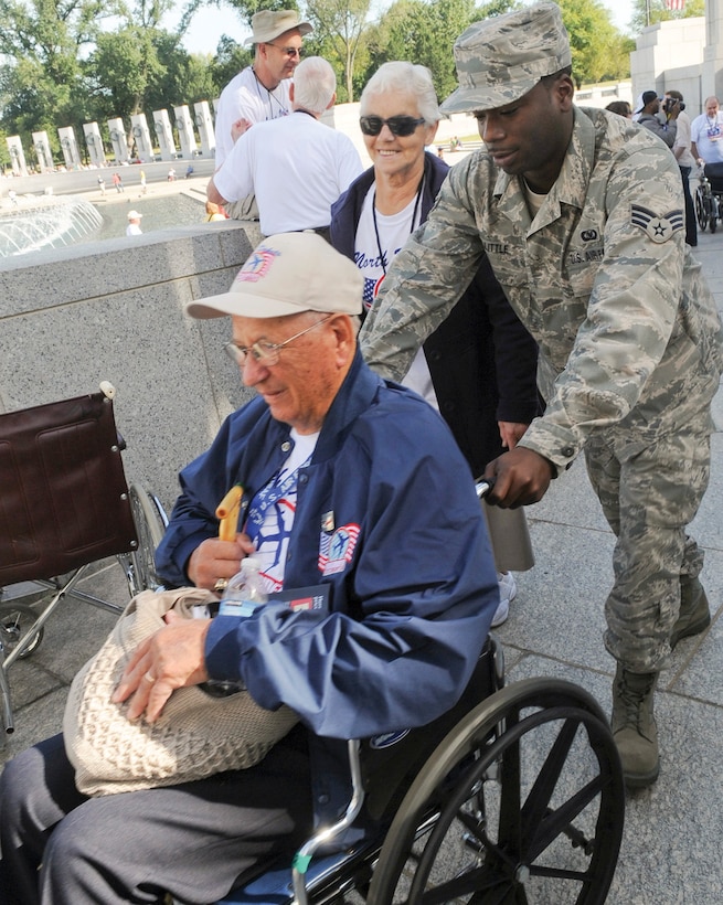 Senior Airman Anthony Little, 316th Wing ground safety technician, escorts a World War II veteran at the World War II memorial in Washington D.C. Sept. 11. WWII veterans and their families flew in from all over the country on behalf of the National Honor Flight program to visit their memorial. For most of the veterans, this was their first time getting to see their memorial. (U.S. Air Force photo/ Bobby Jones)