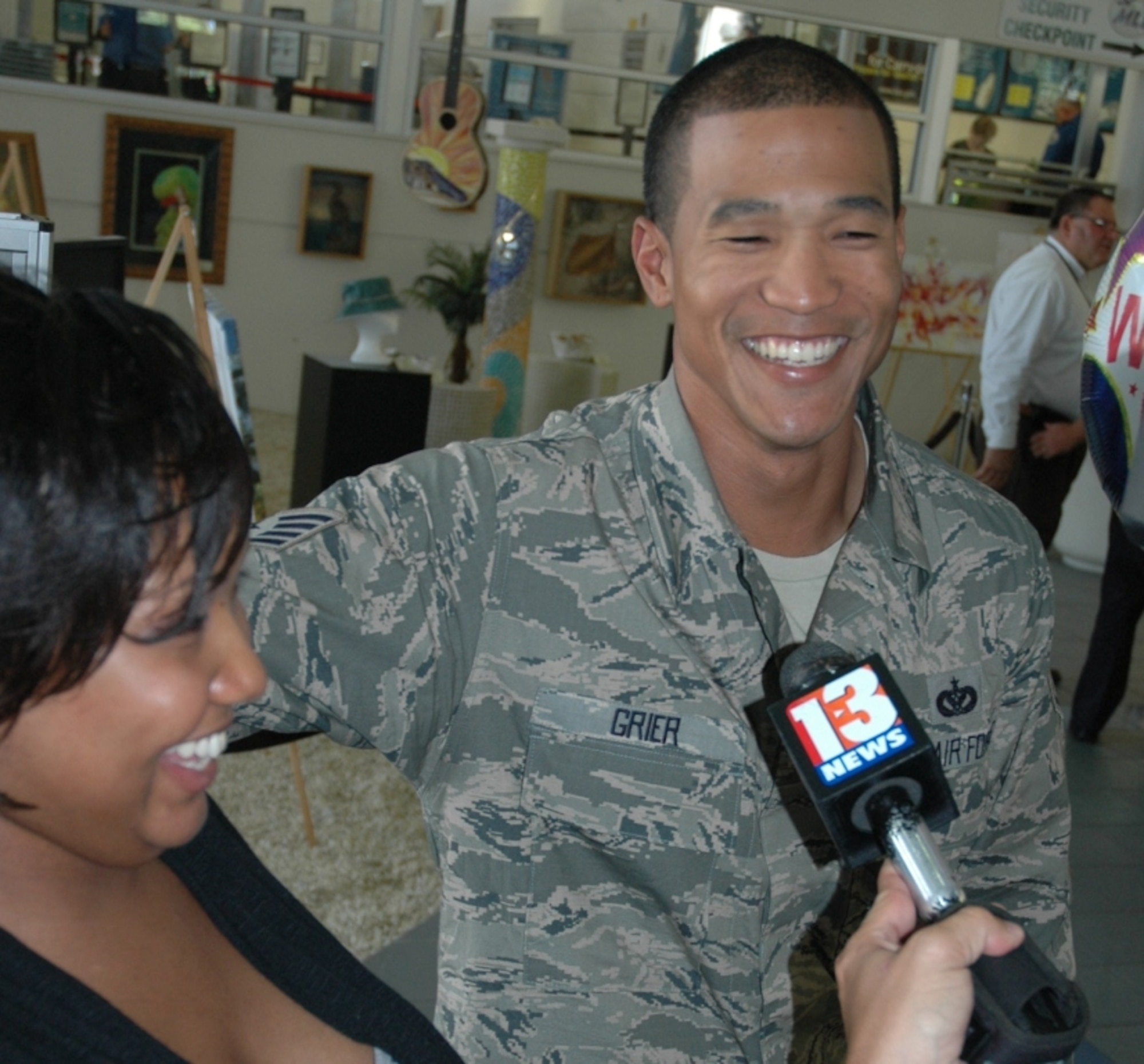 More than 100 friends and family members showed up at Melbourne International Airport Sept. 10 to welcome back approximately 20 Civil Engineer Squadron Airmen from a six-month tour in Afghanistan. Local media were also present to interview our Airmen, including Staff Sgt. Leon Grier, seen here, talking with a Channel 13 reporter. By his side is his wife, Senior Airman Nicole Grier (who recently made the Staff Sgt. promotion list), and who is expecting the couple’s first baby in early November. Welcome home all! Job well done! (U.S. Air Force photo/Eric Brian)