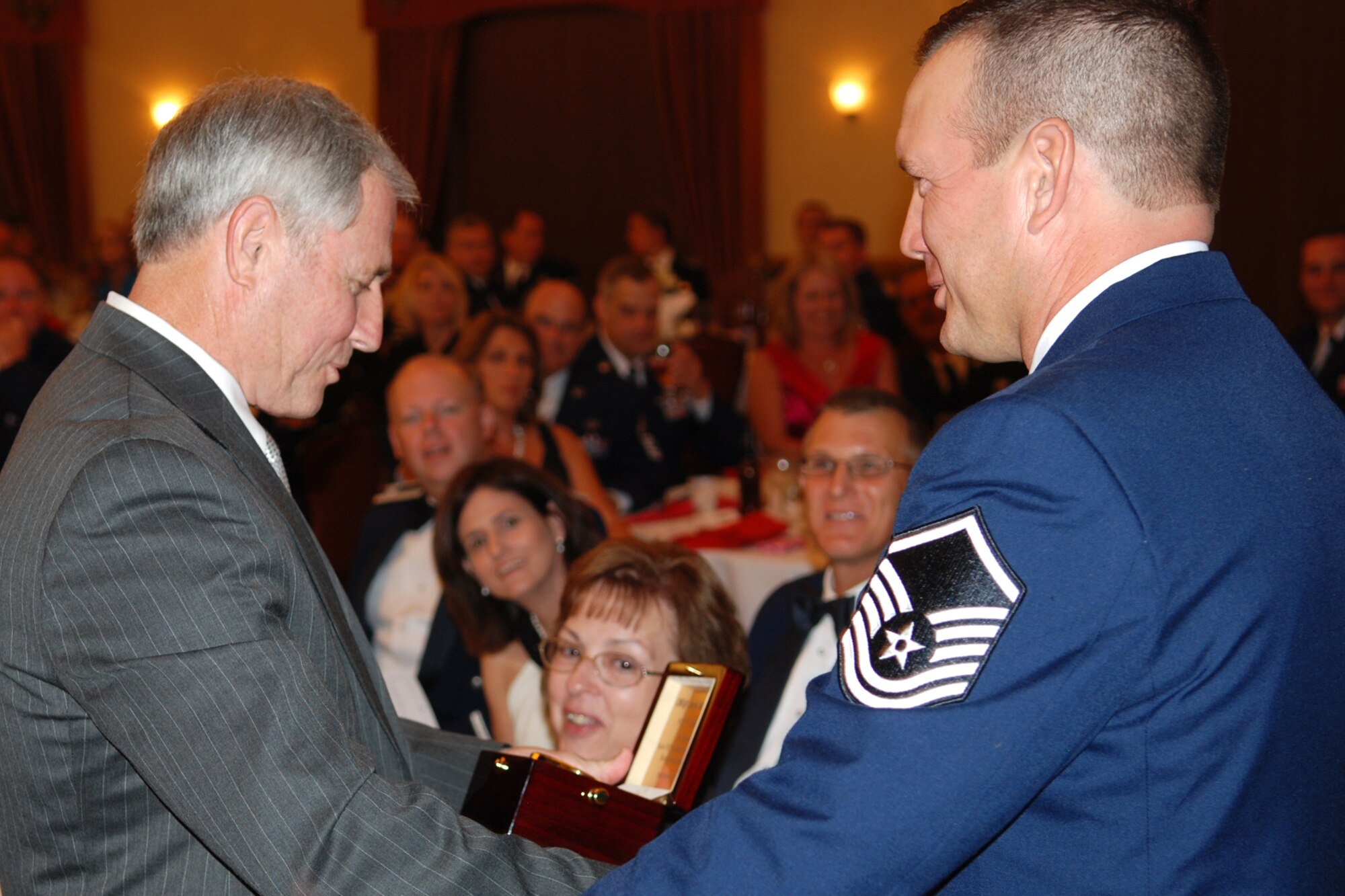 Chief Master Sgt. (Ret) Jack Skaggs, admires the personalized desk clock that Master Sgt. Kerry Rains, jet engine mechanic, 917th Maintenance Squadron, presents to him as guest the speaker for the 917th Wing’s 7th Annual Senior Noncommissioned Officer Induction and Chief’s Recognition Ceremony at the Barksdale Club on Barksdale Air Force Base, La., Sept. 11, 2010. More than 37 Master Sergeants were scheduled to be inducted while three Chief Master Sergeants were recognized at the ceremony. (U.S. Air Force photo/Master Sgt. Greg Steele)
