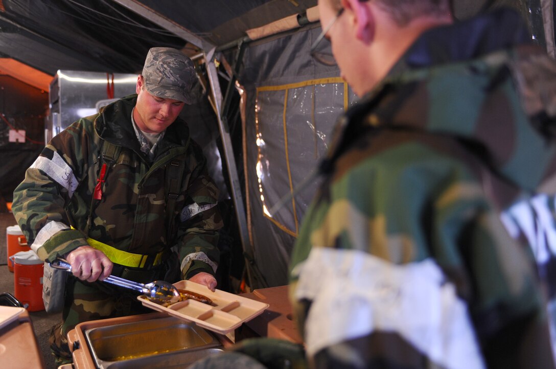 ELLSWORTH AFB, S.D. - Airman 1st Class Reese Audette, 28th Force Support Squadron food services technician, places corn on a tray for an Airman during a phase II operational readiness exercise, Sept. 16. During the exercise, Airmen are tested on their knowledge and abilities while under simulated attacks. (U.S. Air Force photo/Senior Airman Kasey Close)