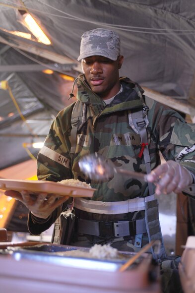 ELLSWORTH AFB, S.D. - Airman 1st Class Terrell Gray, 28th Force Support Squadron food services technician, serves rice for a customer during a phase II operational readiness exercise, Sept. 16. The phase II ORE tested Airmen across the base on their ability to operate in a simulated-deployed environment. (U.S. Air Force photo/Senior Airman Kasey Close)