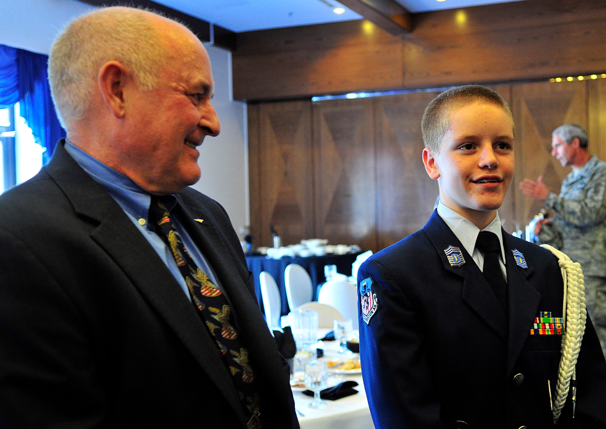 Retired Navy Capt. David Hoffman, former prisoner of war, and Christian Britton, Junior ROTC cadet and son of Senior Master Sgt. Vince Britton, 435th Contingency Response Group superintendent of contingency operations, talk with other military members at the POW/Missing in Action Luncheon, Sept. 17, 2010, at the Ramstein officers? club here.  (U.S. Air Force photo by Senior Airman Amanda Dick)