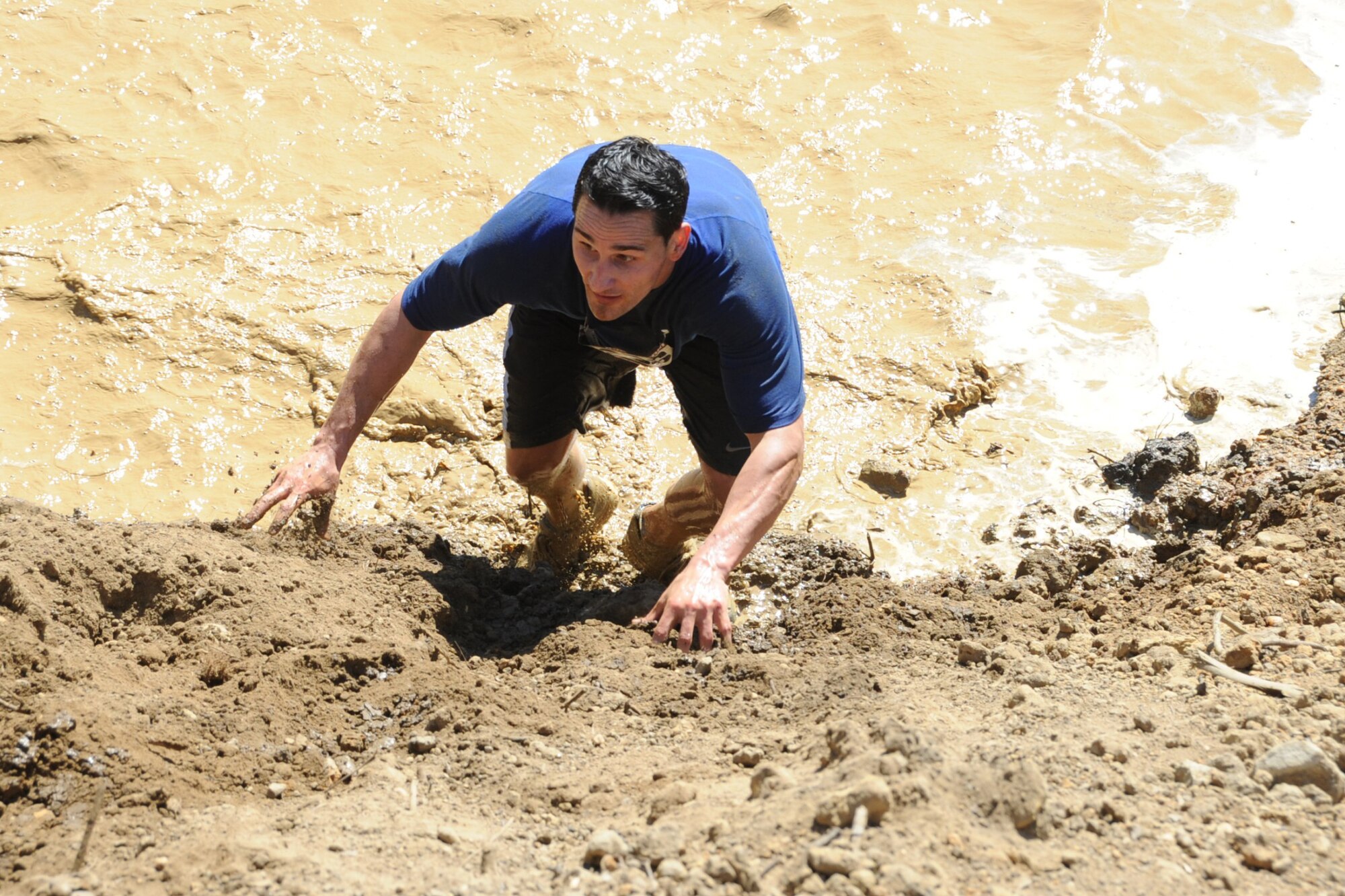 Runner scales one of several mud hills, some more than 10 feet tall on his way to the other obstacles of the "2010 Beast of the East" McGuire Mud Run. (U.S. Air Force photos/Staff Sgt. Danielle Johnson)