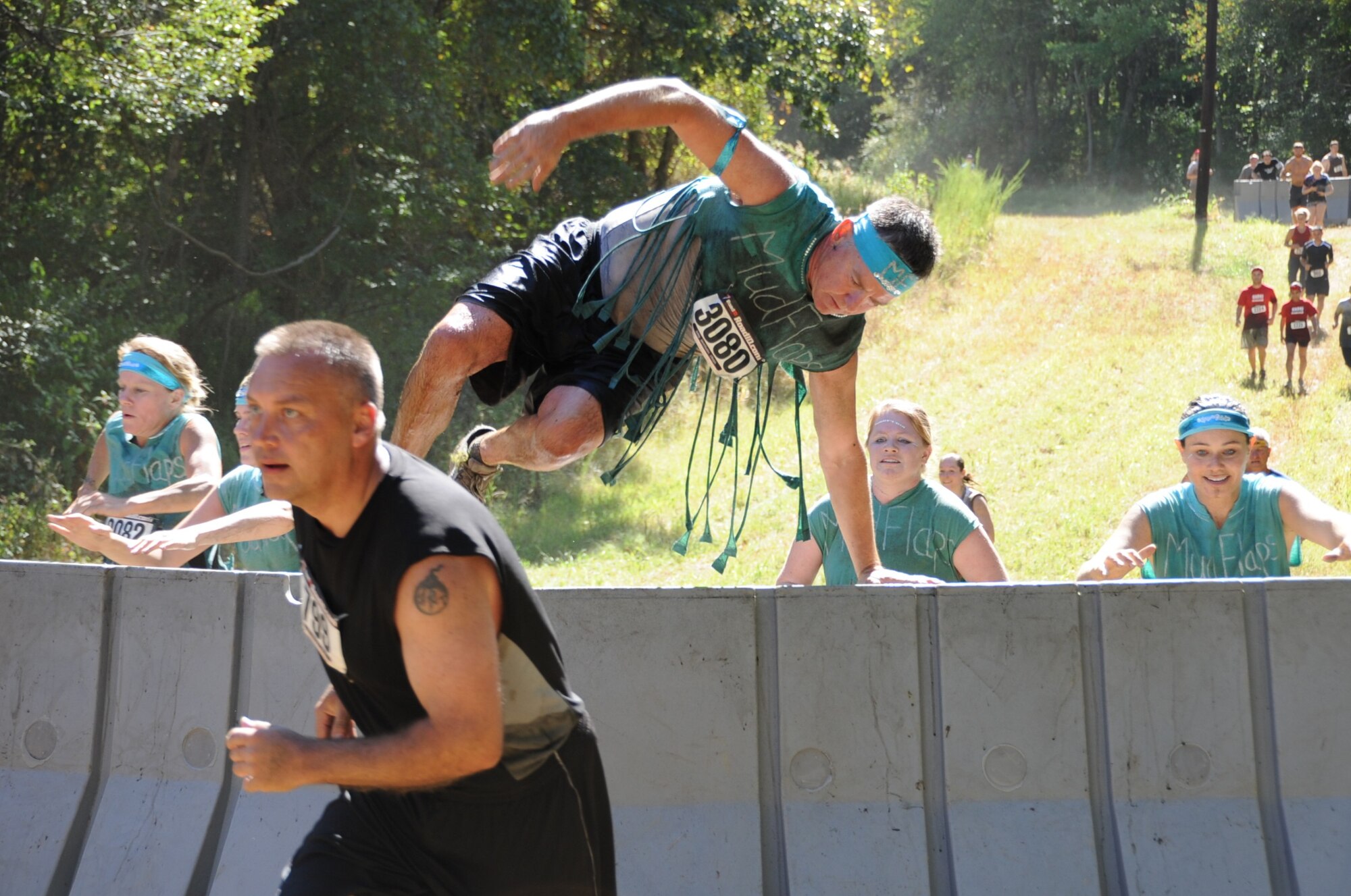 Runners leap over ‘The Hurdles’ obstacle, a series of plastic barriers. More than 3,000 runners came out for the annual event. This year’s 10K course through the wilds of Dix was an expanded version of the 5K held previously at McGuire. (U.S. Air Force photos/Staff Sgt. Danielle Johnson)