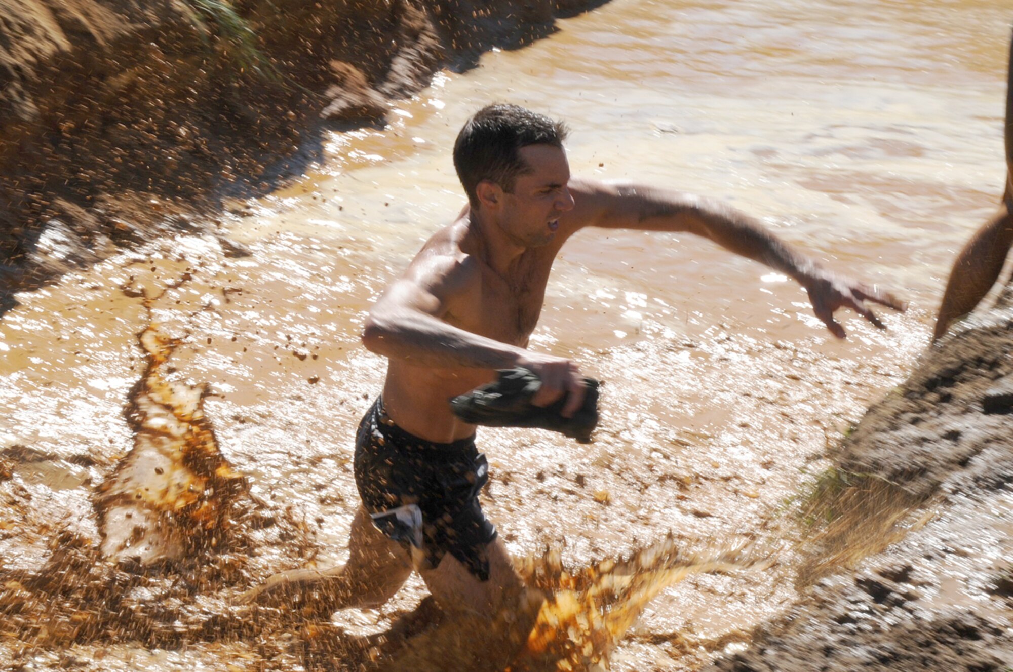 Runners wades through ‘the Pits’, a 3-foot deep trench of muddy waters during the "2010 Beast of the East" McGuire Mud Run Sept. 11. More than 3,000 participants took to the fields of for the challenge of running a 10K through dirt hills, water holes, mud pits, man-made obstacles and stream crossings over terrain that varied from asphalt to grass, sand tank trails and mud. (U.S. Air Force photo/Airman 1st Class Dennis Sloan)