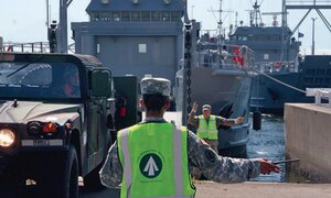 Sgt. Melissa Pollock, 97th Transportation Company, 10th Transportation  Battalion, 7th Sustainment Brigade, guides a Humvee onto the deck of an Army vessel in preparation for Pacific Reach 2010 at Yokohama North Dock, Japan. (Photo by Sgt. 1st Class Sean Riley, Army Sustainment Command Public Affairs Office) 
