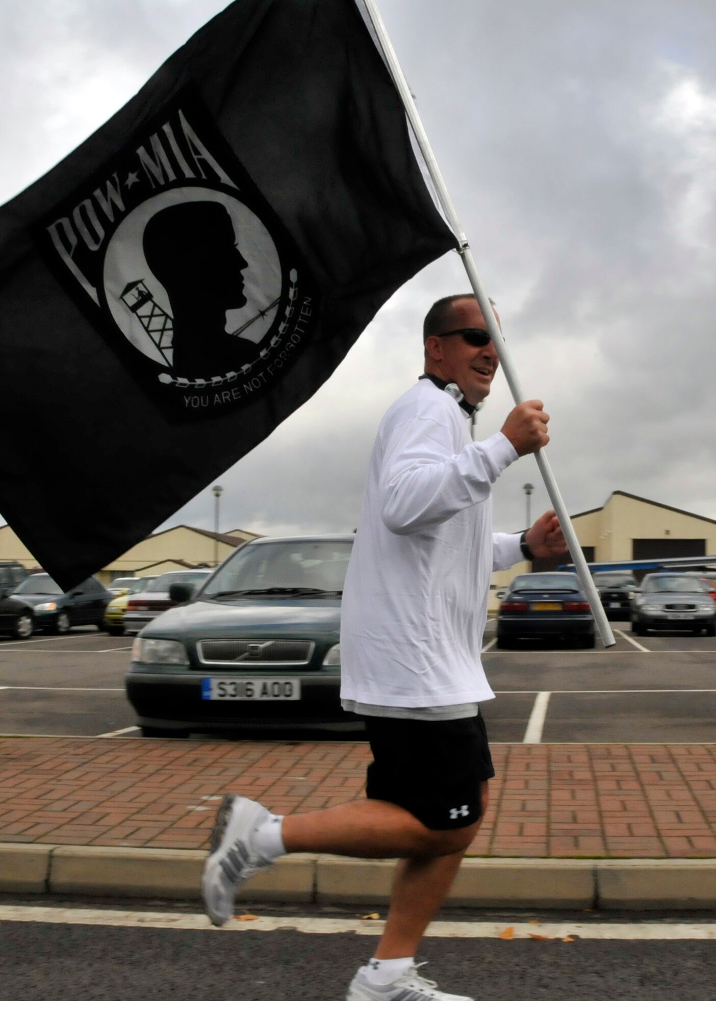 Senior Master Sgt. David Janssen, AFSA Chapter 1669 president, runs with the guidon during the 2010 POW/MIA 5K run Sept.16. The Liberty Wing remembered our POWs and MIAs with a week of base-wide events to honor them. (U.S. Air Force photo/Airman 1st Class Eboni Knox)  