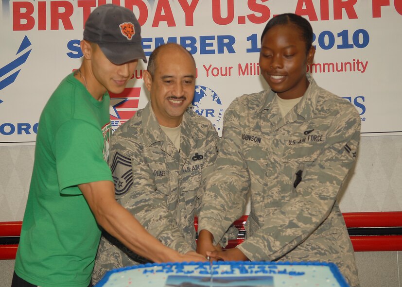 KUNSAN AIR BASE, Republic of Korea -- Airman 1st Class Jendayi Johnson (right), 8th Security Forces Squadron, the Wolf Pack’s youngest Airman, and Chief Master Sgt. Rogelio Olaes, 8th Maintenance Squadron, the Wolf Pack’s oldest Airman, are joined by Army Capt. Lee Jin to help cut the Air Force birthday cake here Sept. 17, 2010. September 17 marks the United States Air Force’s 63rd birthday. (U.S. Air Force photo/Senior Airman Ciara Wymbs) 

