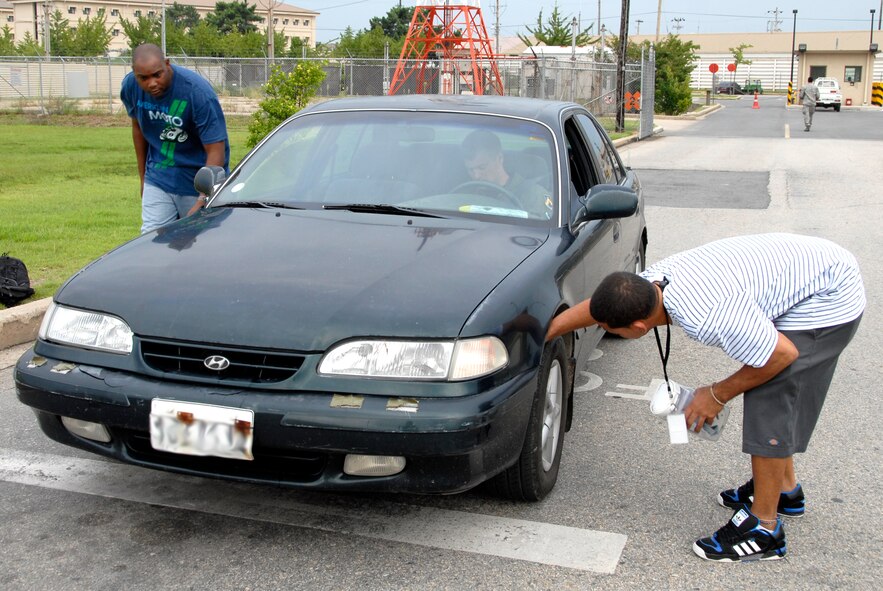 KUNSAN AIR BASE, Republic of Korea -- Tech. Sgt. Kenyun Willis, 8th Communications Squadron, and Senior Airman Raymond Carrasquillo, 8th Maintenance Operations Squadron, perform a foreign-object disposal check for a vehicle entering the flightline. The hispanic heritage committee performed FOD checks as a fundraiser for Hispanic American Heritage Month events here. The fundraiser raised more than $500. (U.S. Air Force photo/Staff Sgt. Amanda Savannah)