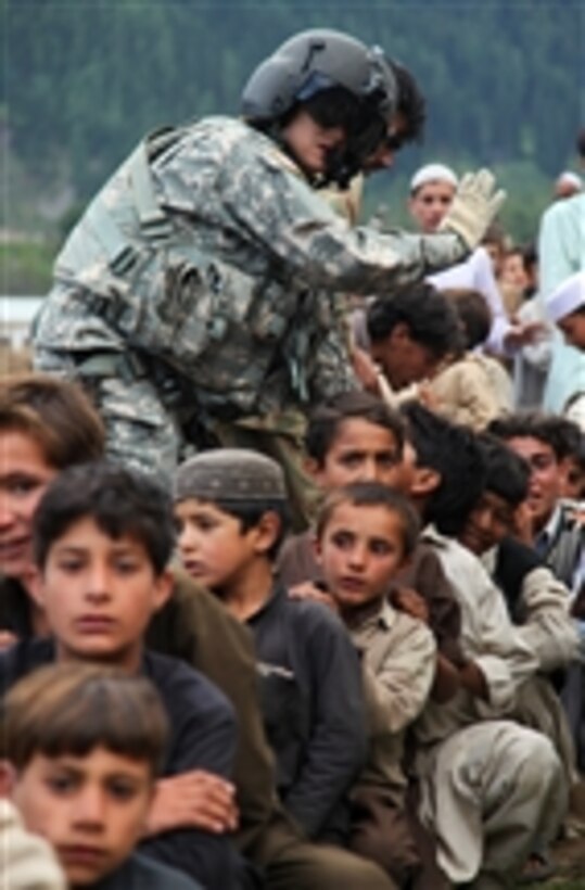 Pakistani children wait to be moved onto a U.S. Army CH-60 Black Hawk helicopter for evacuation in Khyber-Pakhtunkhwa province, Pakistan, on Sept. 13, 2010.  The flood affected nearly 20 million Pakistanis forcing many from their homes.  