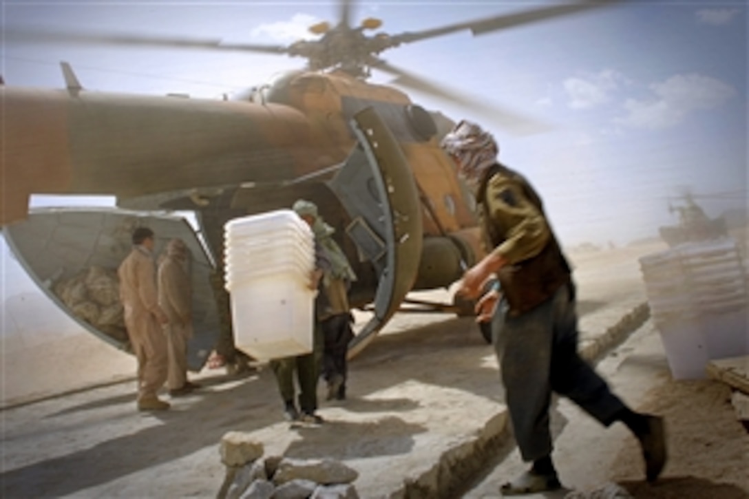 Afghan civilians and Afghan National Army soldiers unload ballot materials from an Mi-17 helicopter in Jaghuri, Afghanistan, Sept. 16, 2010. The ballots will be used in the Sept. 18 elections when Afghans will elect the lower house of parliament.