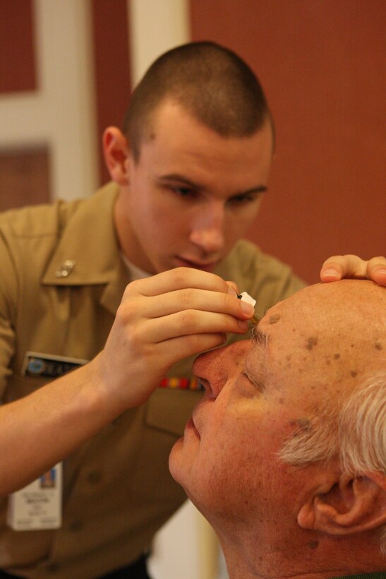 Seaman Bradley Beaton (left), a corpsman with Naval Hospital Camp Lejeune, applies eye drops to a retired service member during the Retiree Appreciation Day at Marston Pavilion aboard Marine Corps Base Camp Lejeune, Sept. 18. The event formally recognizes the contributions the retired service members have made, as well as offers free medical screening.