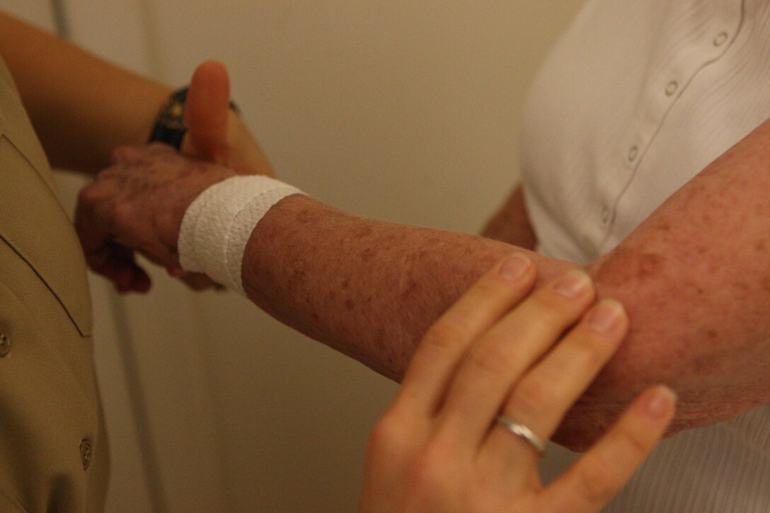 A visual skin cancer test is conducted on a military retiree during the Retiree Appreciation Day at Marston Pavilion aboard Marine Corps Base Camp Lejeune, Sept. 18. The event featured a Naval Hospital Camp Lejeune health and wellness fair, which had free medical testing services ranging from blood pressure checks to skin cancer screenings to proper nutrition information.