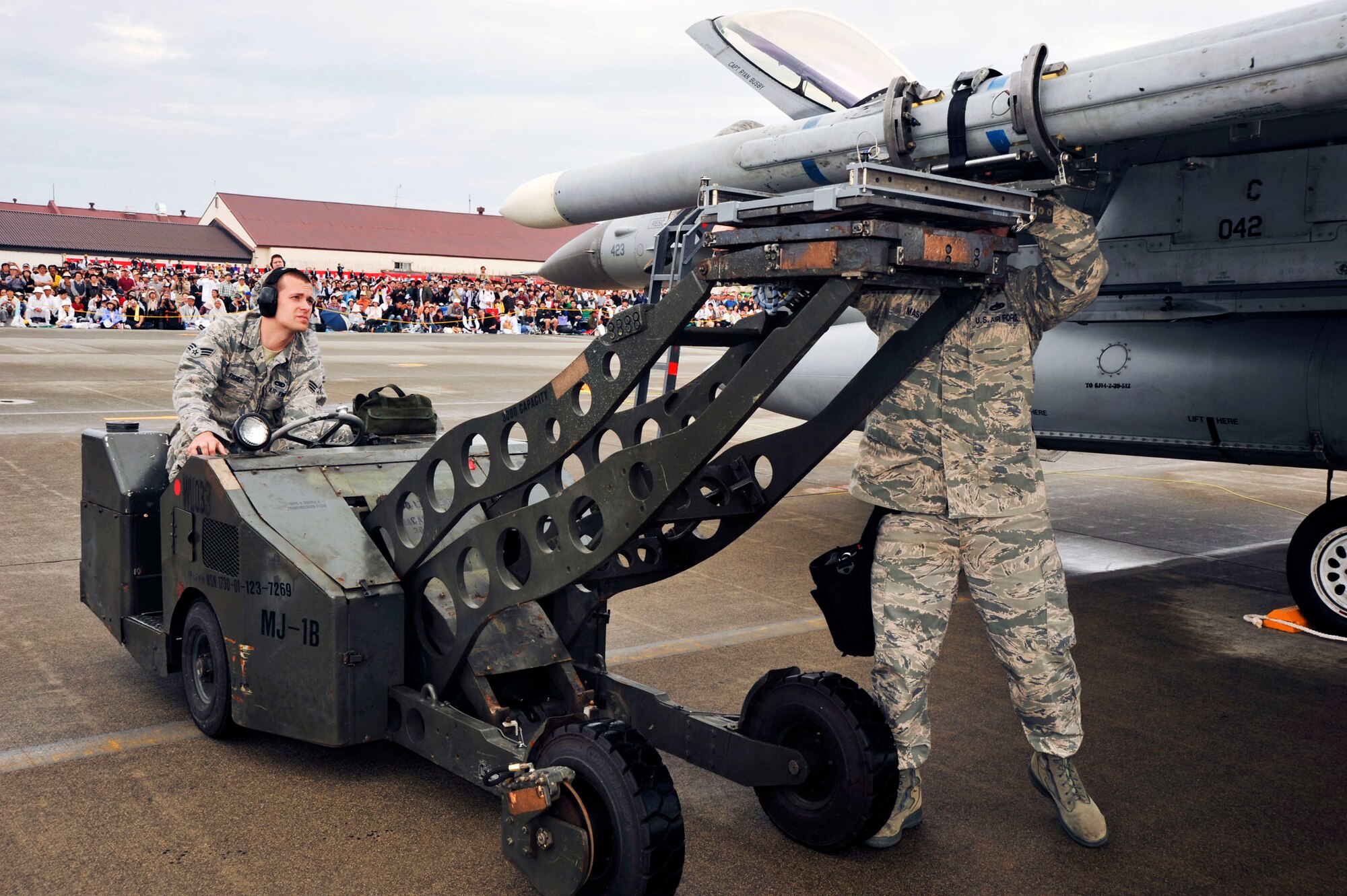 Senior Airman Benjamin Fisher, left, and Staff Sgt. William Massey, 35th Maintenance Operations Squadron, load munitions onto an F-16 Flying Falcon during a weapons loading demonstration at the Misawa Air Festival, here, Sept. 19, 2010. Sergeant Massey and Airmen Fisher joined other load crews to participate in the annual air festival team demonstrations. (U.S. Air Force Photo/Tech. Sgt. Russell McBride) (Released)