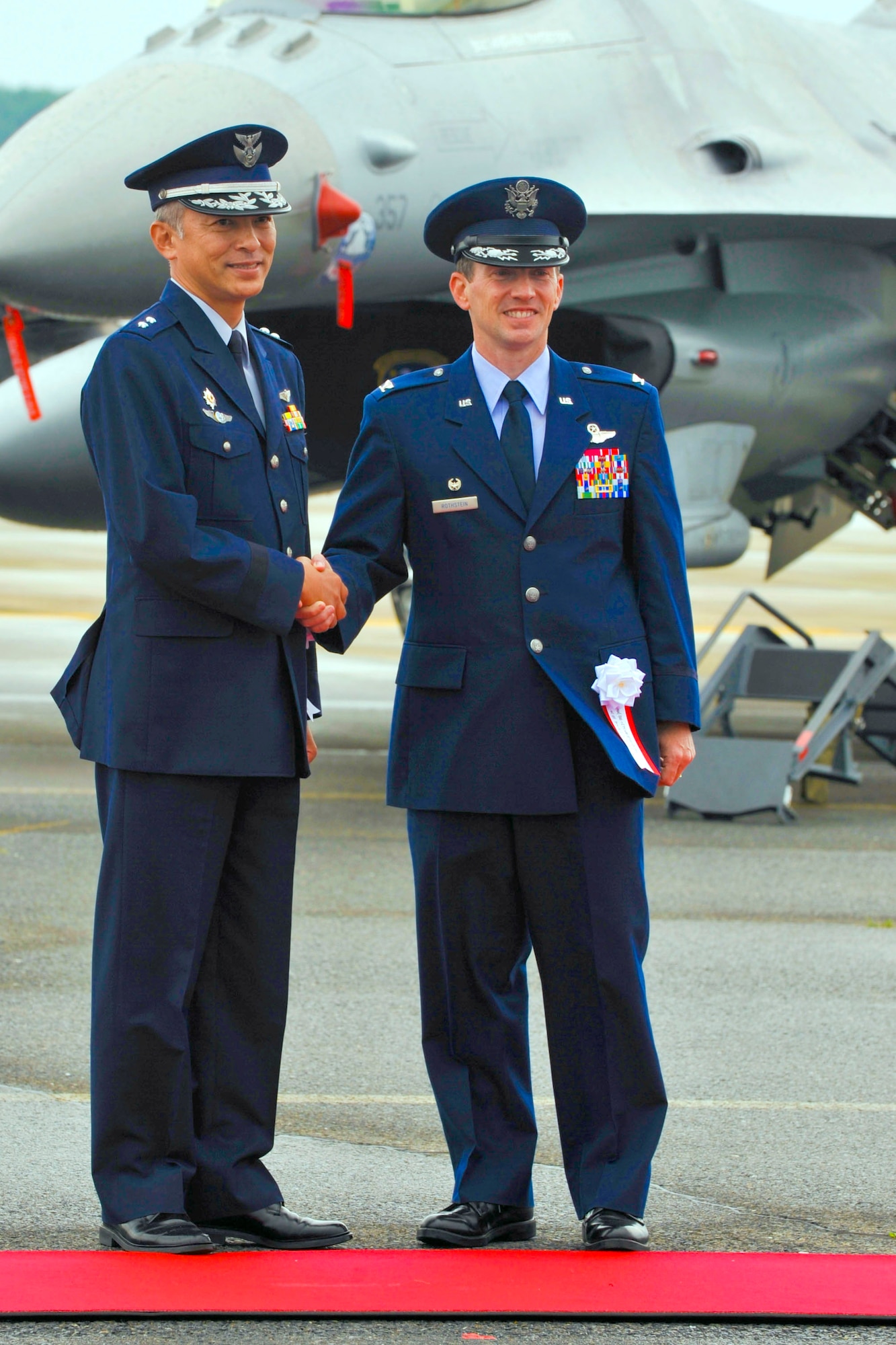 Japan Air Self-Defense Force Maj. Gen. Hideo Maehara, 3rd Air Wing Commander, and U.S. Air Force Col. Michael Rothstein, 35th Fighter Wing commander, pause for a photo opportunity in front of an F-16 during the Misawa Air Festival at Misawa Air Base, Japan, Sept. 19, 2010. Included in this year?s events are a performance by the Blue Impulse Demonstration Team, aerial maneuver demonstrations and weapons-loading demonstrations. (U.S. Air Force Photo/Tech. Sgt. Russell McBride) (Released)