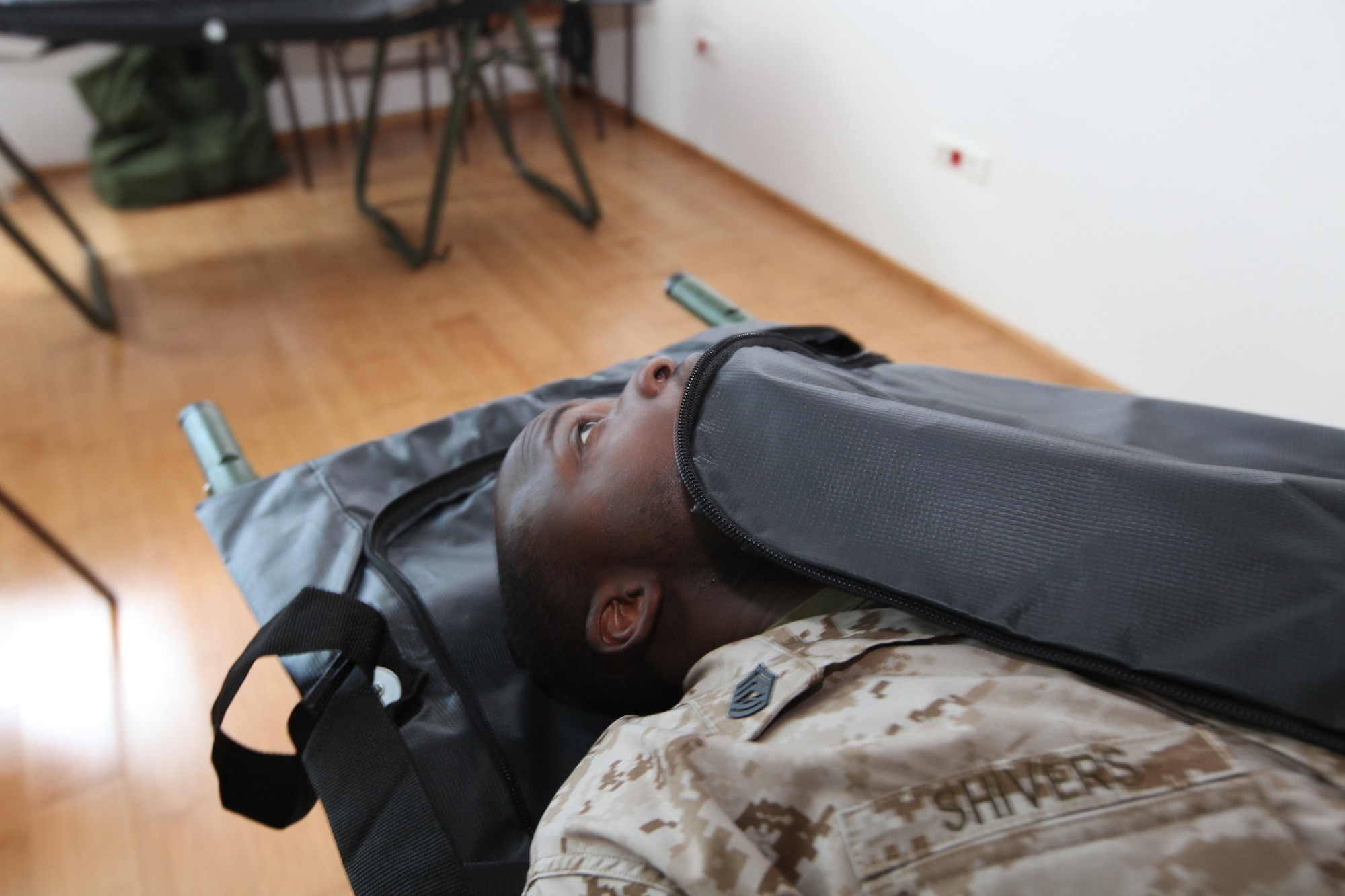 Gunnery Sgt. Octavius Shivers, the non-commissioned officer in charge of Detachment Personnel Retrieval and Processing, Smyrna, Ga., crawls into a human remains pouch during a class for foreign forces as part of Medical Training Exercise in Central and Eastern Europe 2010 at Danilovgrad Army Base, Montenegro. MEDCEUR 10 is an annual U.S. Joint Chiefs of Staff-sponsored exercise meant to improve mass casualty disaster response and increase interoperability between the U.S. and participating nations. For more information, go to www.usafe.af.mil/medceur.asp and www.odbrana.gov.me. (U.S. Marine Corps photo/Lance Cpl. Jad Sleiman)